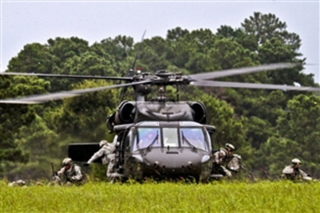 Soldiers exit from a UH-60 Black Hawk helicopter during an air insertion exercise on Fort Pickett, Va., Aug. 17, 2013.