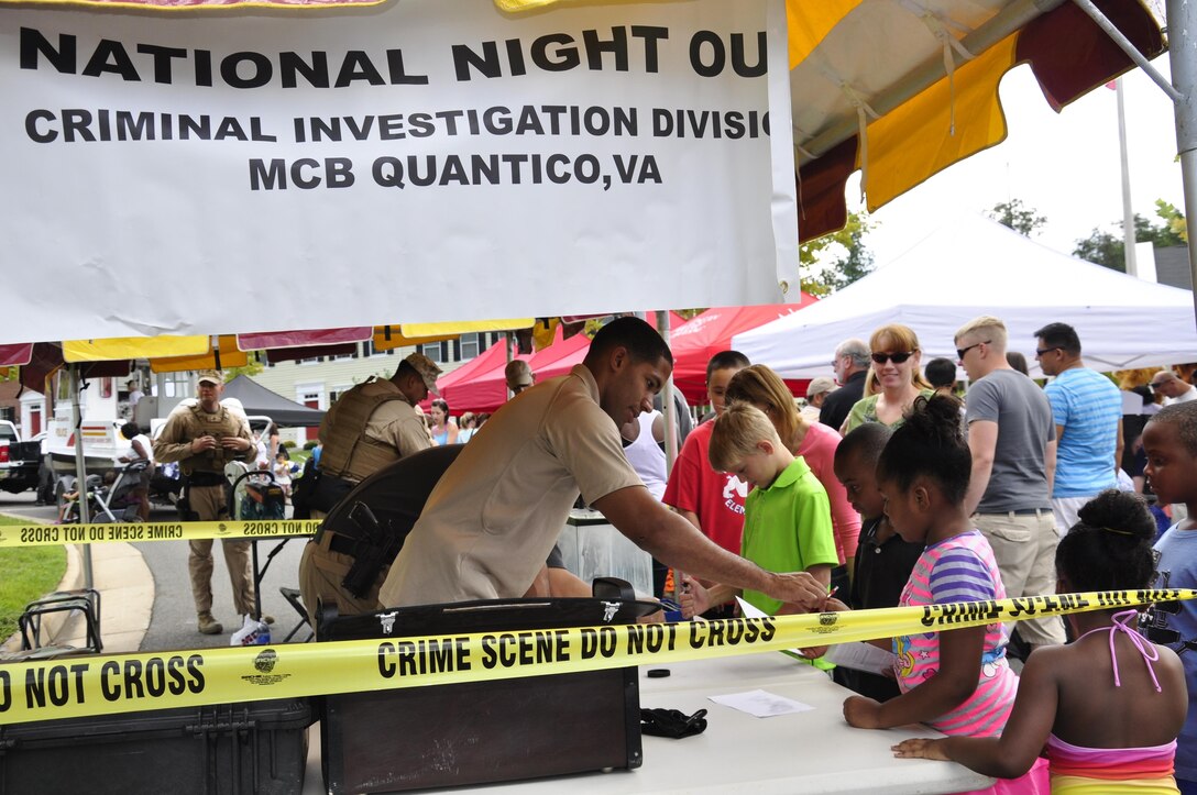 Members of the Naval Criminal Investigation Division demonstrate how they dust for fingerprints at the 2013 National Day Out: Back to School Event on Aug. 18, 2013, outside of the Lincoln Military Housing Family Housing Center aboard Marine Corps Base Quantico. The Provost Marshal's Office, Marine Corps Community Services and Lincoln Military Housing co-sponsored the event after National Night Out was cancelled on the base due to budget cuts.