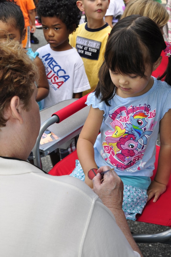 Ayanna, 4, gets a ladybug painted on her hand at the facepainting booth during 2013 National Day Out: Back to School Event on Aug. 18, 2013, outside of the Lincoln Military Housing Family Housing Center aboard Marine Corps Base Quantico. The Provost Marshal's Office, Marine Corps Community Services and Lincoln Military Housing co-sponsored the event after National Night Out was cancelled on the base due to budget cuts.