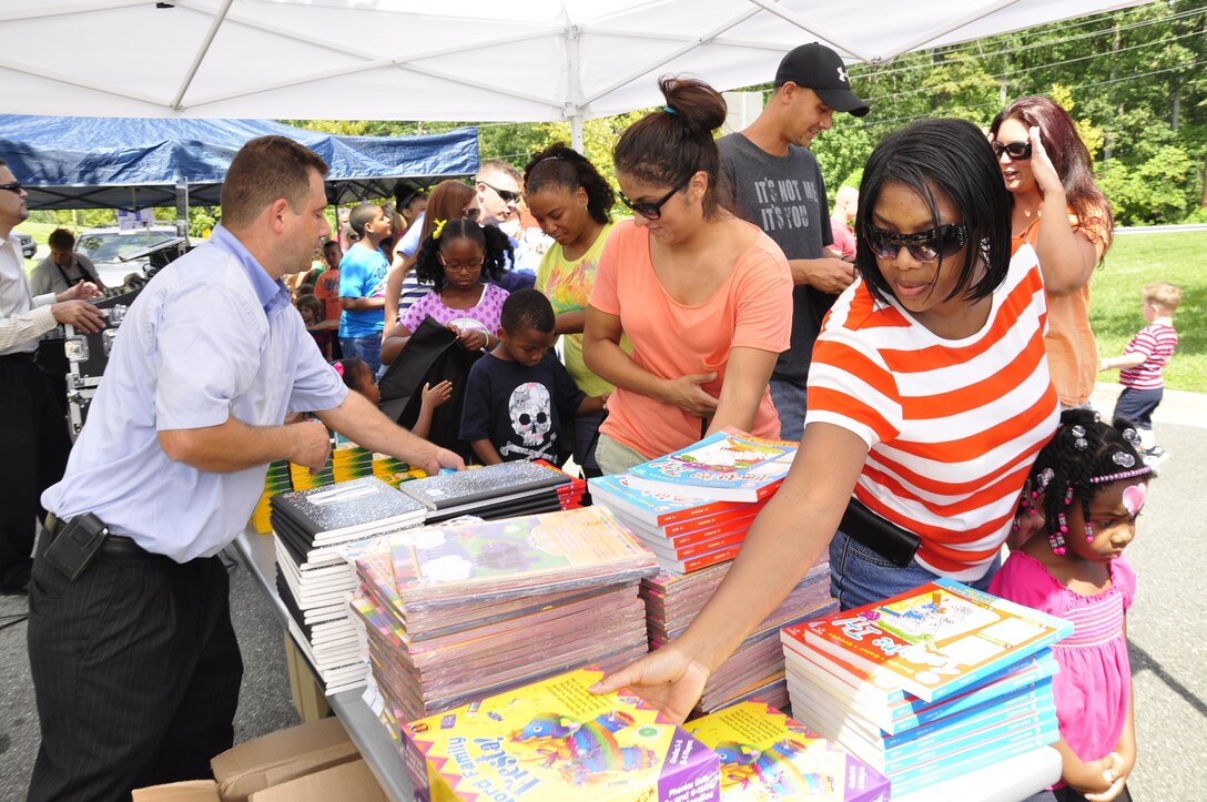 Service members and their families receive school supplies at the 2013 National Day Out: Back to School Event on Aug. 18, 2013, outside of the Lincoln Military Housing Family Housing Center aboard Marine Corps Base Quantico. The Provost Marshal's Office, Marine Corps Community Services and Lincoln Military Housing co-sponsored the event after National Night Out was cancelled on the base due to budget cuts.