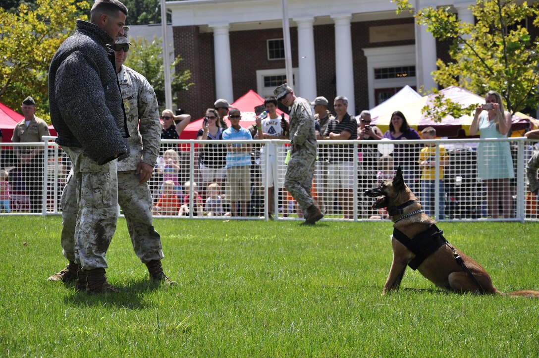 The Provost Marshal's Office K-9 unit demonstrate their dogs obedience skills to service members and their families during the 2013 National Day Out: Back to School Event on Aug. 18, 2013, outside of the Lincoln Military Housing Family Housing Center aboard Marine Corps Base Quantico. The Provost Marshal's Office, Marine Corps Community Services and Lincoln Military Housing co-sponsored the event after National Night Out was cancelled on the base due to budget cuts.