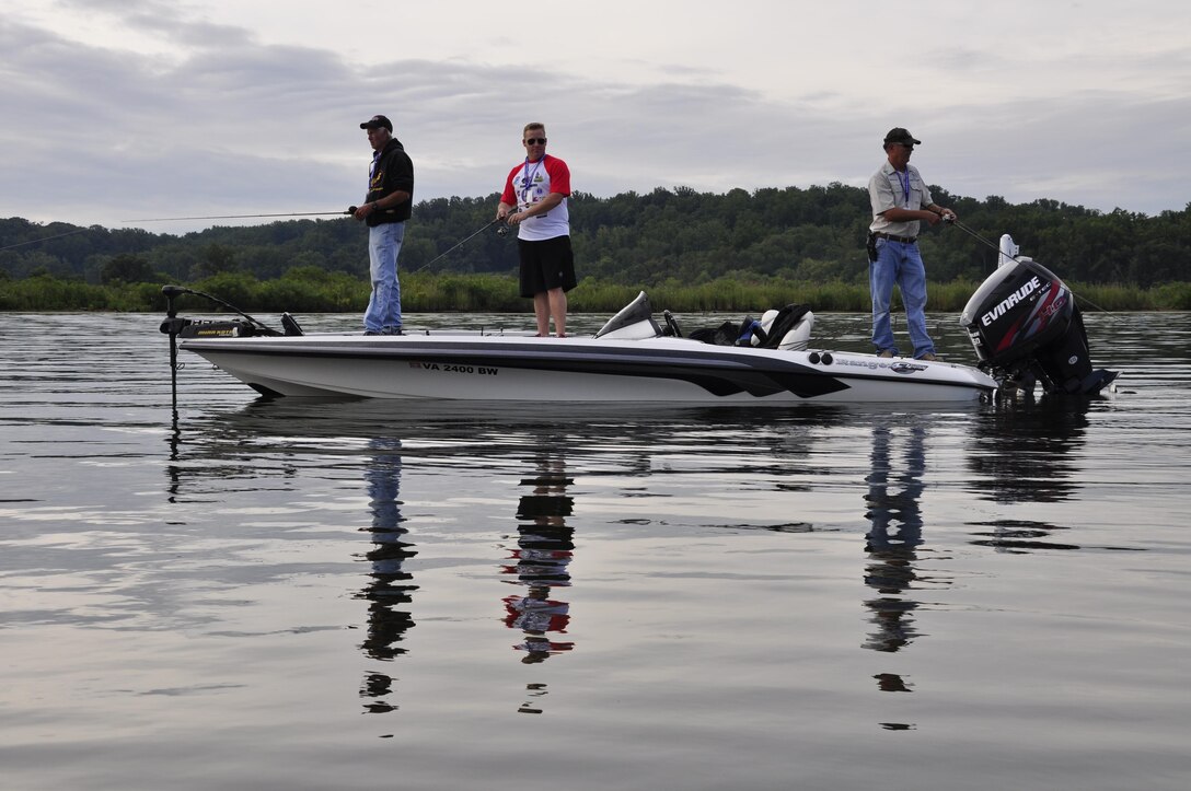 Two local bass anglers teach a wounded warrior to fish during the Third Annual Reel American Heroes Fishing Tournament try their hands at bass fishing Aug. 18, 2013. Approximately 80 wounded warriors and their local bass angler participated. The tournament started at the Hope Springs Marina, but participants were allowed to fish anywhere, so long as they made it back on time.