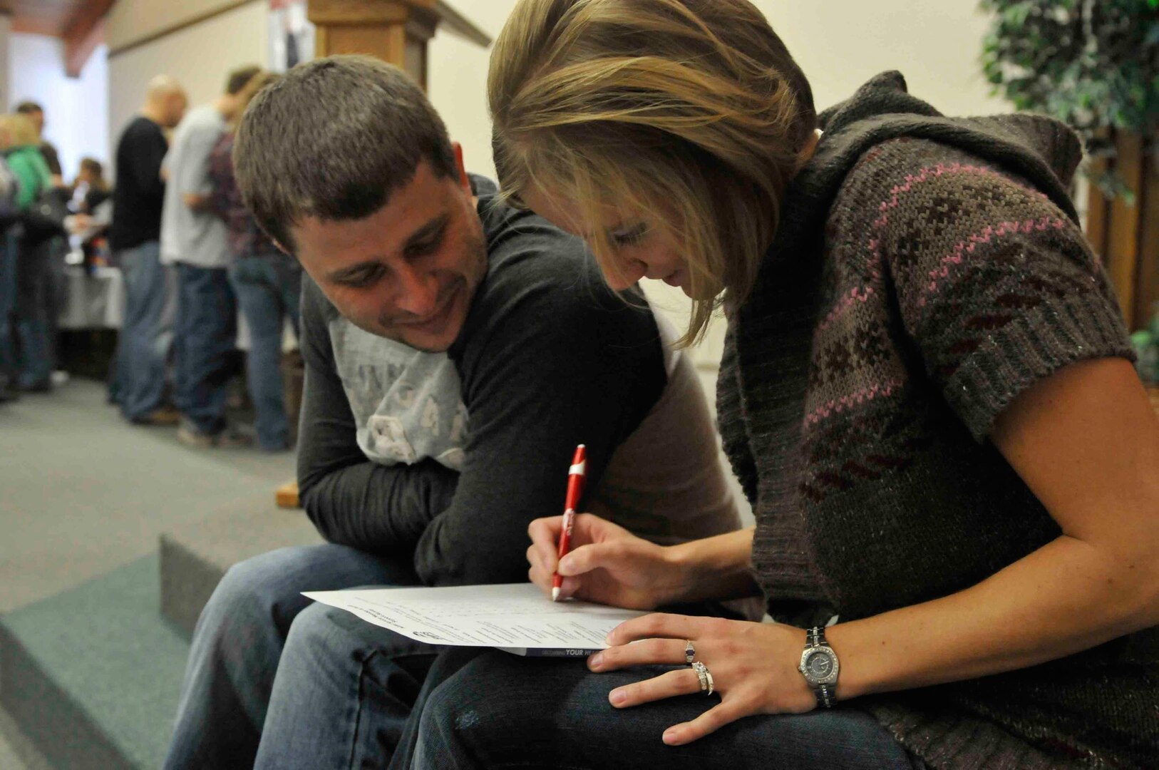 Army Sgt. Tosha Kunrath and her husband, Scott Kunrath, fill out a military survey after attending the "Laugh Your Way to a Better Marriage" conference.