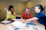 Fort Jackson's Survivor Outreach Services Coordinator, Leslie Smith, left, goes over paperwork with South Carolina Army National Guard's Beth Carney, center, and the Army Reserve's Megan McCullough, right, during a recent meeting at the 81st Regional Support Command headquarters building on Fort Jackson, S.C.