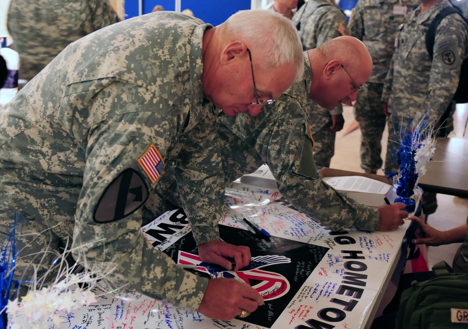 Maj. Gen Dennis Celletti, the assistant adjutant general for Army of the Illinois National Guard, right, and Command Sgt. Maj. John Starbody, the senior enlisted adviser for the Illinois Army National Guard, sign a banner to honor the Soldiers who took part in the injured warrior muster at Rock Island Arsenal Garrison, Oct. 18, 2010.