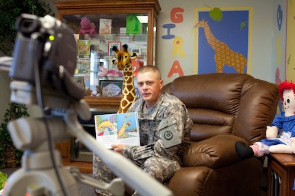 Spc. Robert Snyder of the 220th Transportation Company records a video reading "Danny the Dinosaur" for his children at the United Through Reading room in the USO center at Camp Atterbury Joint Maneuver Training Center, Ind., June 10, 2010. The United Through Reading program allow Soldiers separated from their families by deployments, like Snyder, to remain connected through recordings of them reading books for their children.