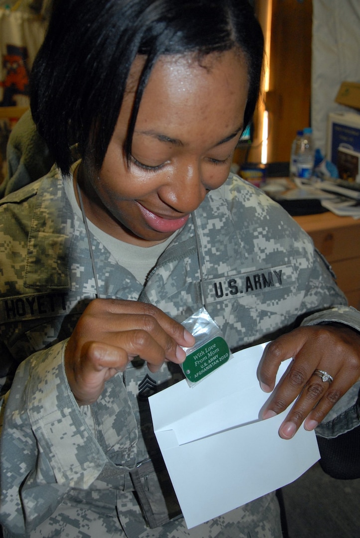 Serving in Afghanistan, Sgt. 1st Class Maryland Hoyett places a dog tag into an envelope to mail to her 12-year-old daughter Ciare in Nashville, Tenn.