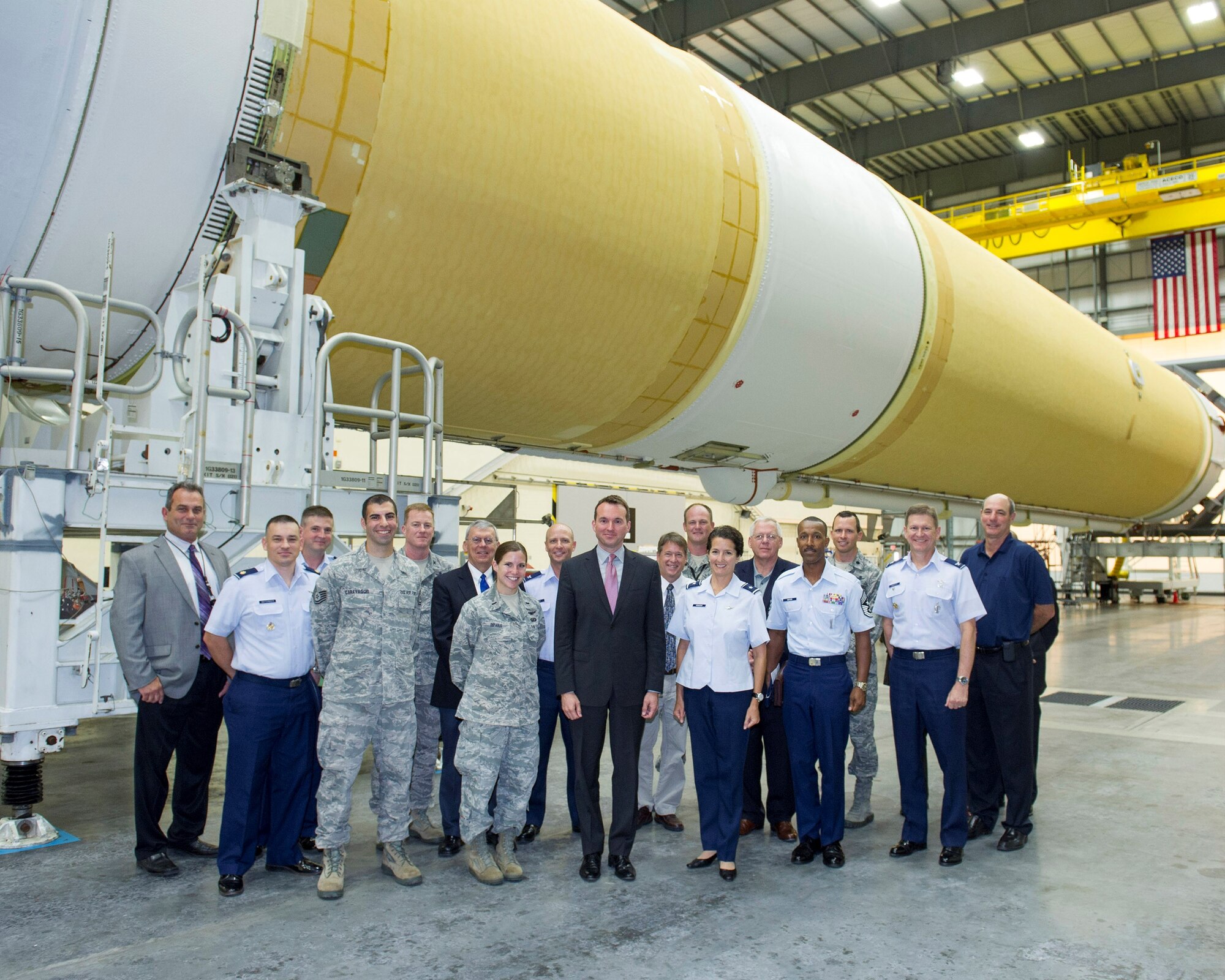 Acting Secretary of the Air Force Eric Fanning poses with Brig. Gen. Nina Armagno (right), 45th Space Wing commander, in front of a Delta IV launch vehicle during his tour of the Horizontal Integration Facility at Cape Canaveral Air Force Station Aug. 8, 2013, given by 1st Lt. Danielle DePaolis, 5th Space Launch Squadron engineer (left of Fanning). (U.S. Air Force photo/Matthew Jurgens)