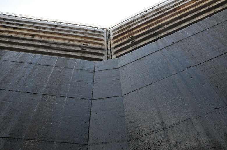 Kentucky Lock’s upper miter gates at the top of this photo play a very significant role while maintenance repairs are being made in the dewatered chamber. They are holding back the waters of not only Kentucky Lake, but also of Lake Barkley as the Barkley Canal joins the two lakes upstream of their respective dams. The lock has been dewatered to permit TVA-contracted GUBMK Constructors to sandblast, make any needed internal structural repairs, and paint the 91-foot tall miter gates at the lower end. The U.S. Army Corps of Engineers Nashville District employees dewatered the 69-year-old, 110-by-600-foot lock and will inspect the culvert valves and all other areas of the lock that are normally underwater for any needed repairs. Corps employees will also replace the tow haulage system, used to move unpowered sections of barge tows through the lock. Kentucky lock is scheduled to resume normal operation at noon, Sept. 24, 2013.