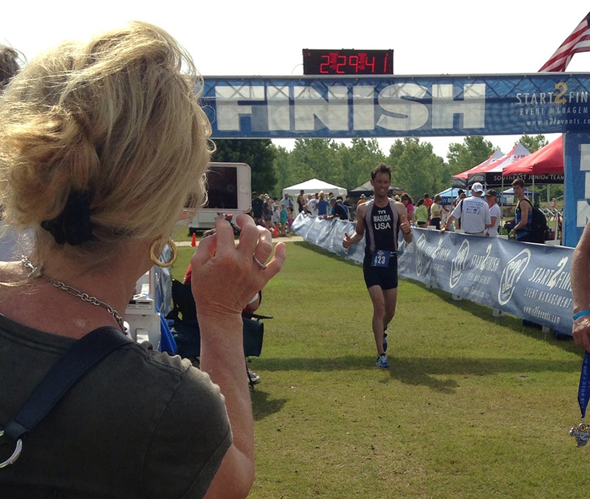 Maj. Michael Masuda, C-17 instructor pilot with the 313th Airlift Squadron, here at McChord Field, Wash., effortlessly finishes the Memphis in May Olympic Triathlon in Memphis, Tenn. May 19, where he also qualified for the U.S. National Championships for Olympic Triathlons. Whether at home or flying missions with the Reserve, Masuda maintains his fitness regimen and constantly trains to compete in Olympic-distance triathlons, which consist of a 1.5-kilometer swim, 40-kilometer bike, and 10-kilometer distance run.  (Courtesy photo)