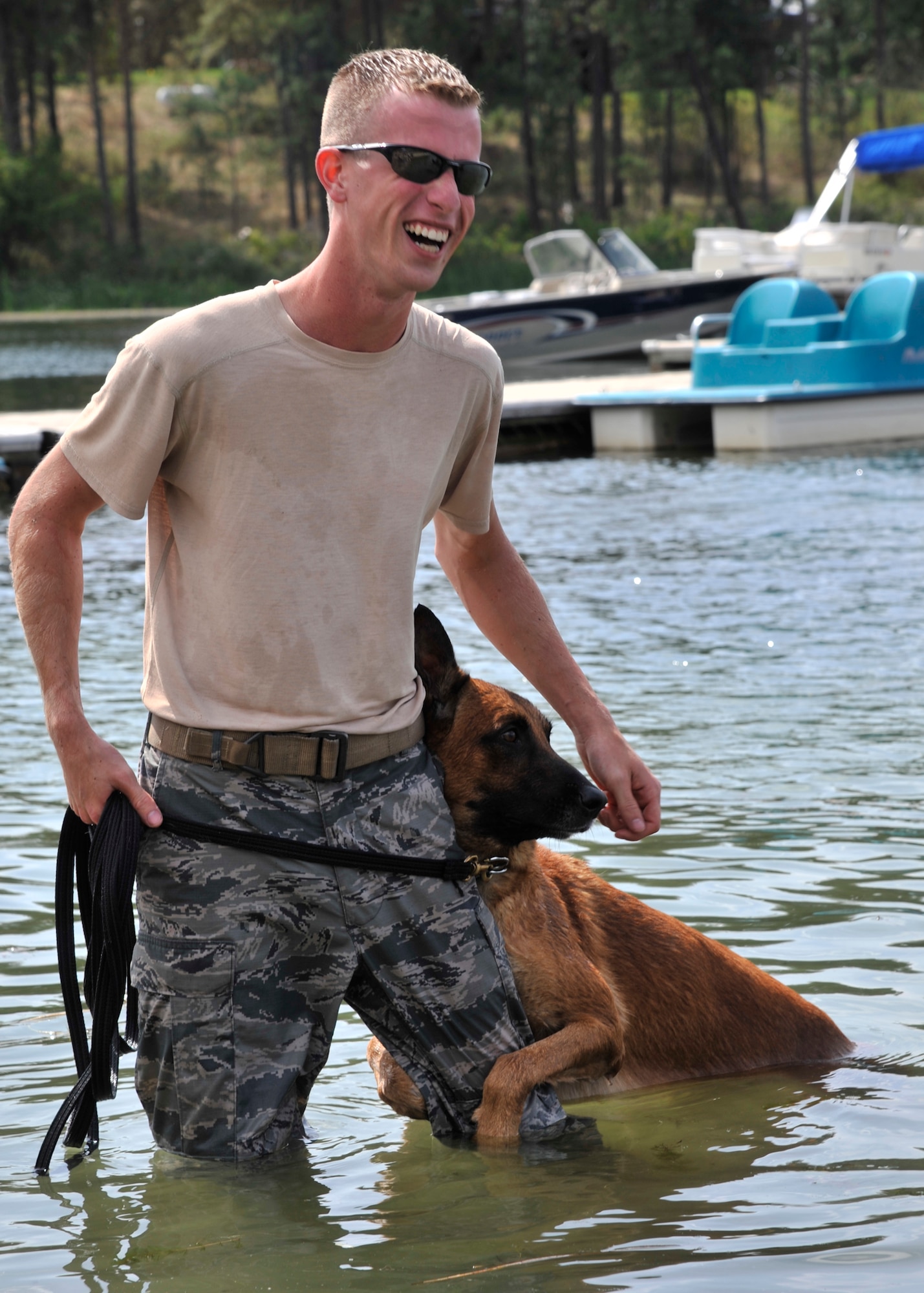 Military working dog Uutah clings to his handler, Staff Sgt. Justin Benfer, 92nd Security Forces Squadron, in the water at Clear Lake Resort in Cheney, Wash., Aug. 16, 2013. The MWDs perform training exercises in the water to keep up their confidence in different environments and stay mission-ready at all times. (U.S. Air Force photo by Senior Airman Mary O'Dell/Released)