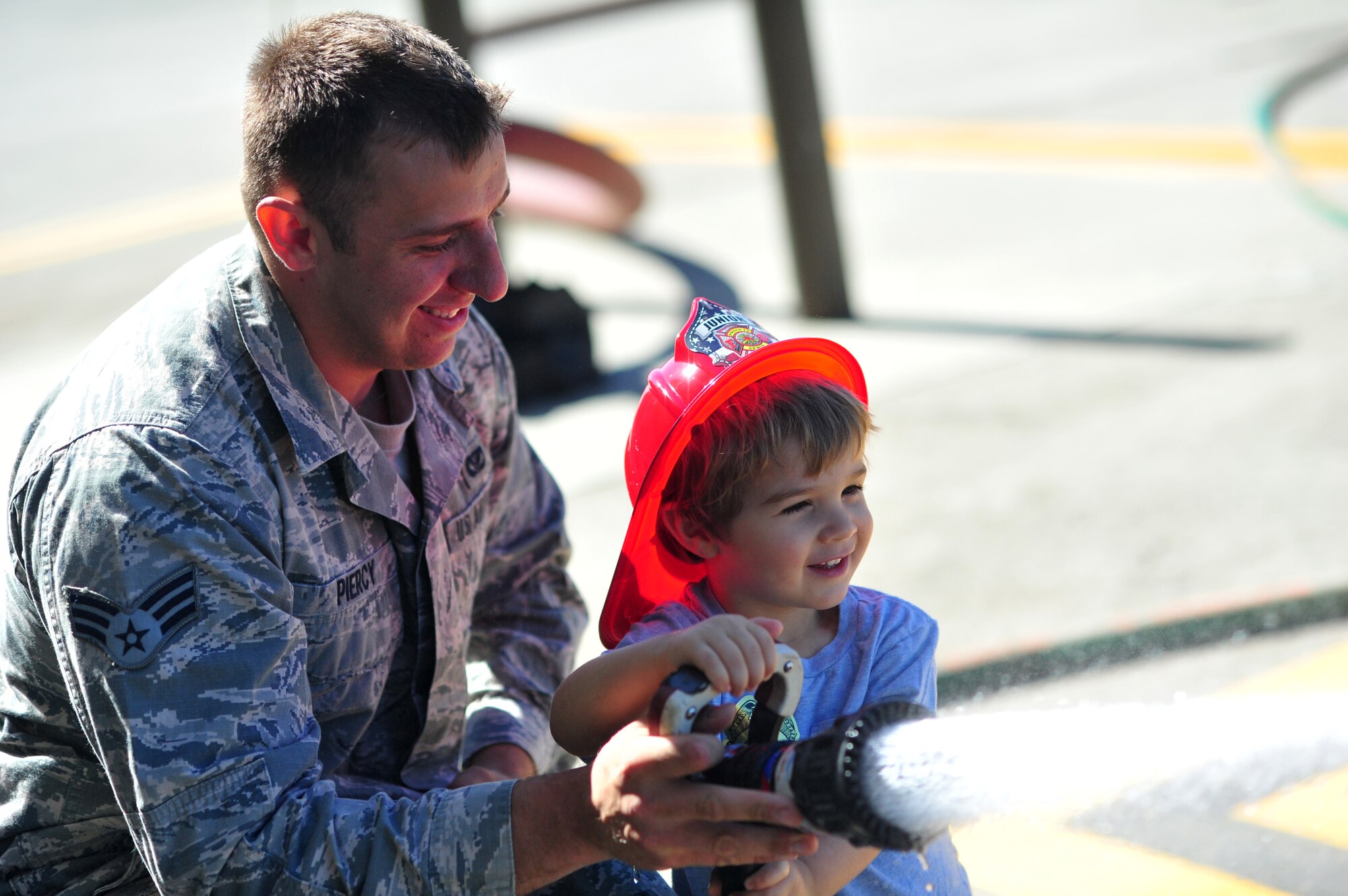 Children use the fire truck hose during the Family Recognition Day event at Fairchild Air Force Base, Wash., Aug. 19, 2013. The event was made possible by the hard work of Fairchild’s Airmen and multiple base agencies. (U.S. Air Force photo by Senior Airman Taylor Curry/Released))