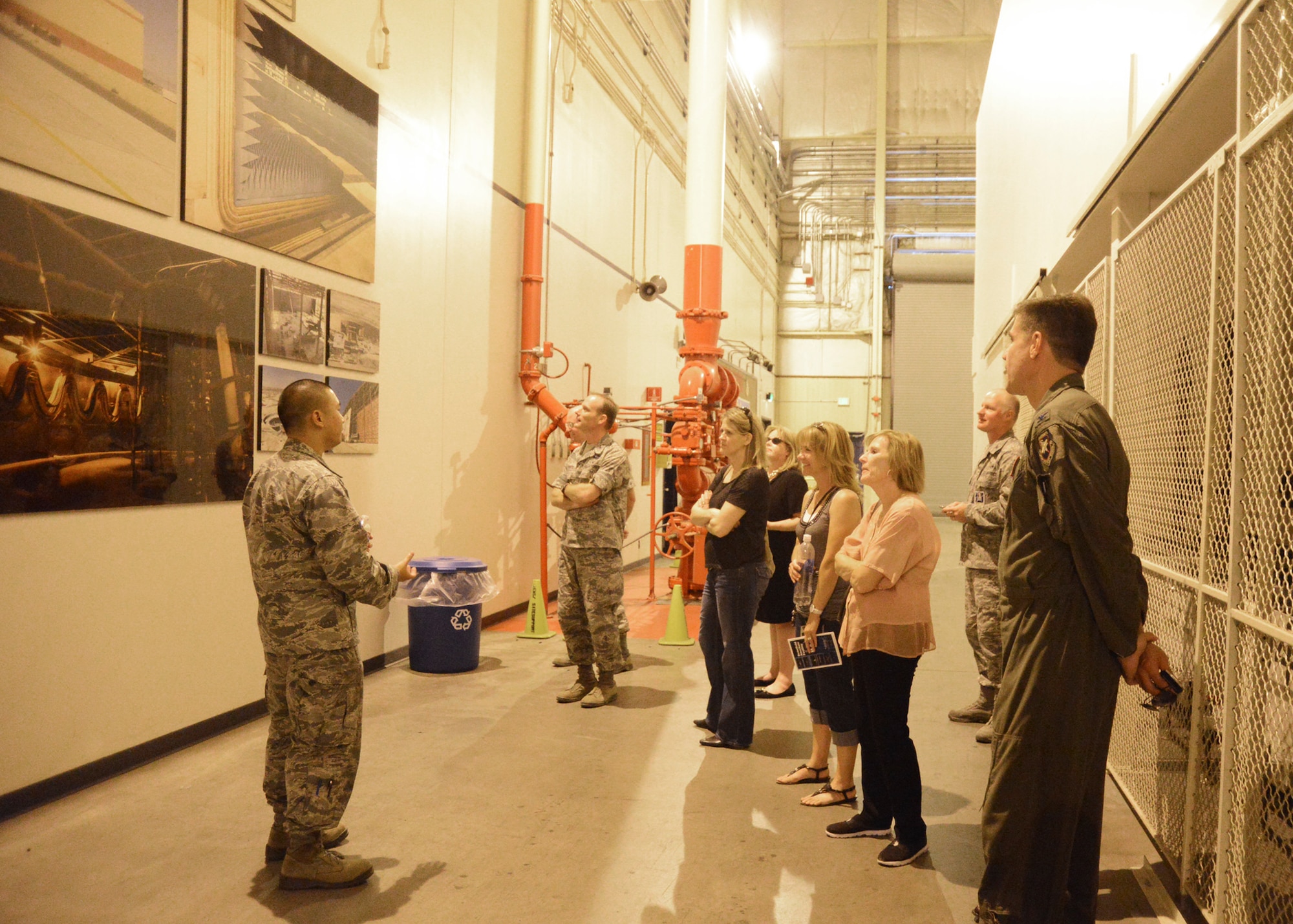Lt. Elbert Chan, 412th Electronic Warfare Group, project lead engineer, shows his group of commanders and honorary commanders photographs that demonstrate how the Benefield Anechoic Facility operates. (U.S. Air Force photo by Rebecca Amber)