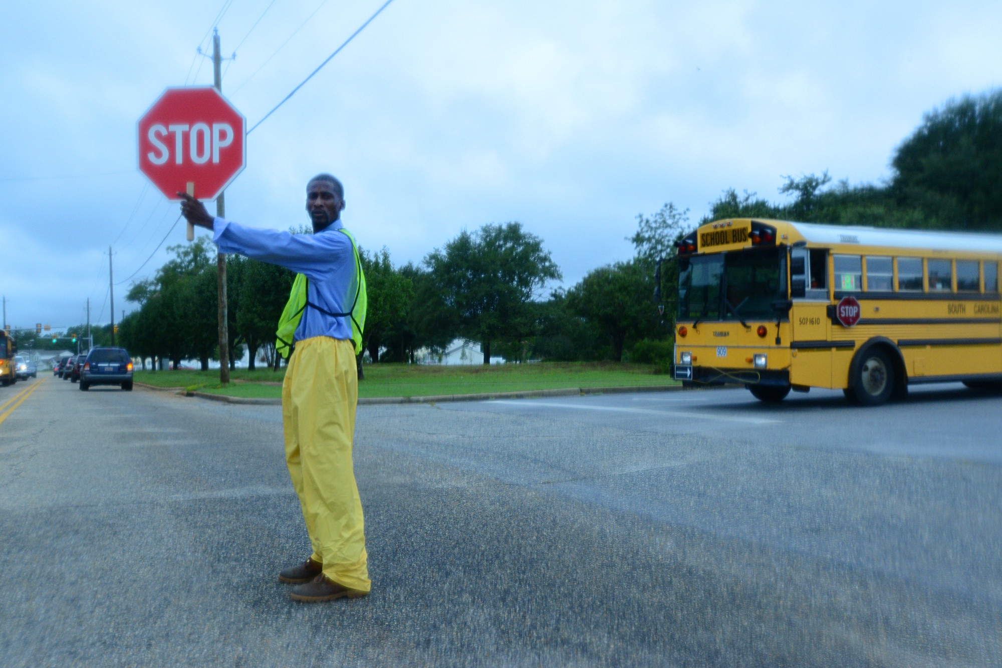 Andre Bradley, a custodian for the Sumter School District, stops traffic for a school bus, Shaw Air Force Base, S.C., Aug. 19, 2013. Bradley directed the busy traffic in front of Shaw Heights Elementary on the first day of school.  (U.S. Air Force photo by Airman 1st Class Jensen Stidham/Released)