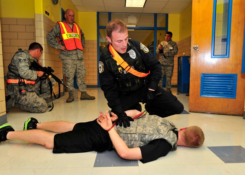 Justin Viens, 436th Security Forces Squadron, apprehends an active shooter suspect Aug. 13, 2013, at Major George S. Welch Elementary School on Dover Air Force Base, Del. Viens, along with other law enforcement and medical personnel were responding to an active shooter scenario that was part of the major accident response exercise. (U.S. Air Force photo/Tech. Sgt. Chuck Walker)