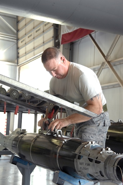 U.S. Air Force Staff Sgt. Lyle Eagan, 7th Munitions Squadron load crew member, connects a jammer to a GBU-54 during a practice load Aug. 8, 2013, at the load barn on Dyess Air Force Base, Texas. Crew members are trained on loading approximately 16 different weapons, with the most common being the joint direct attack munitions, or JDAM. (U.S. Air Force photo by Senior Airman Shannon Hall/Released)