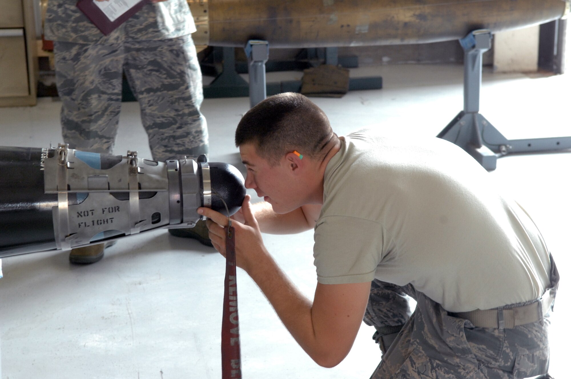U.S. Air Force Airman 1st Class Dustin Evans, 7th Munitions Squadron load crew member, inspects a GBU-54 during a practice load Aug. 8, 2013, at Dyess Air Force Base, Texas. Load crew members are evaluated and recertified every month to ensure their weapon loading skills remain precise and up to Air Force standards. (U.S. Air Force photo by Senior Airman Shannon Hall/Released)
