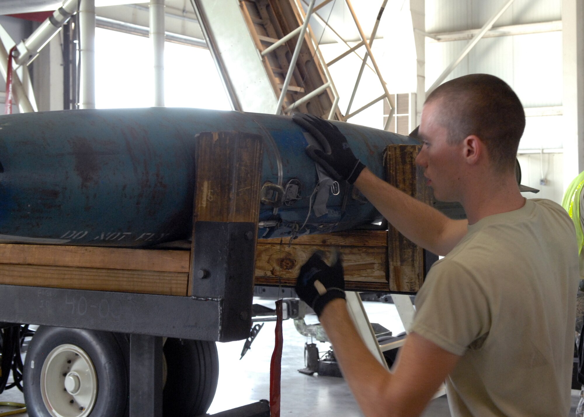U.S. Air Force Airman 1st Class Zakk Bunting, 7th Munitions Squadron load crew member, inspects a Mark-82 air during a practice load Aug. 8, 2013, at Dyess Air Force Base, Texas. Load crew members are evaluated and recertified every month to ensure their weapon loading skills remain precise and up to Air Force standards. (U.S. Air Force photo by Senior Airman Shannon Hall/Released)