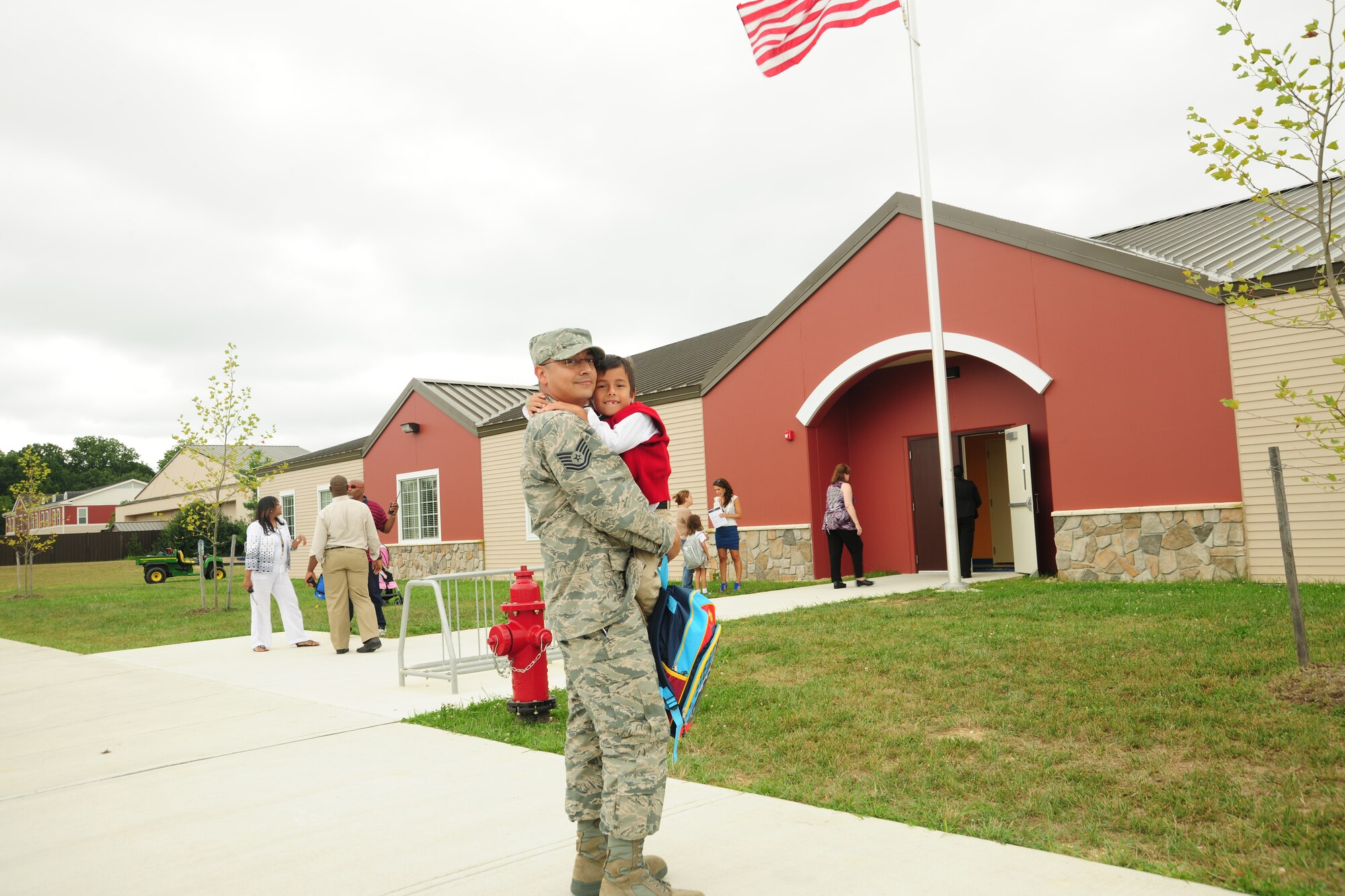 Tech. Sgt. Kalub Chavez, Air Force District of Washington mission controller, embraces his son Isaiah after his first day in the first grade at Imagine Andrews Public Charter School on Joint Base Andrews, Md., Aug. 19, 2013. Military members makeup 65 percent of the families at IAPCS. (U.S. Air Force Photo/ Ms. Amber J. Russell)