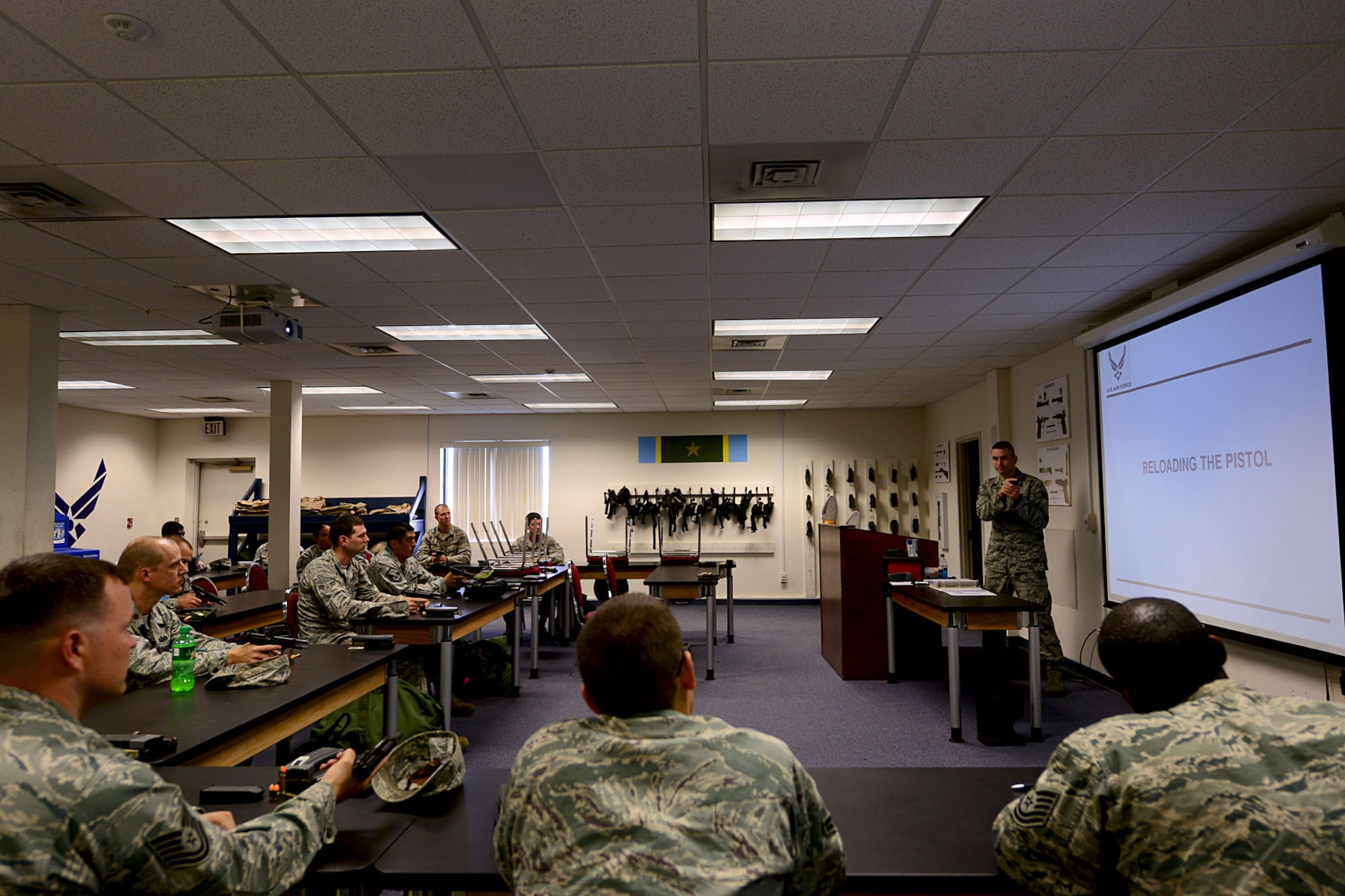 U.S. Air Force Staff Sgt. William Delphia, 633rd Security Forces Squadron combat arms training and maintenance instructor, demonstrates reloading procedures for the M9 Beretta pistol at Langley Air Force Base, Va., Aug. 13, 2013. Delphia teaches approximately 15 to 20 students daily. (U.S. Air Force photo by Staff Sgt. Ashley Hawkins/Released)