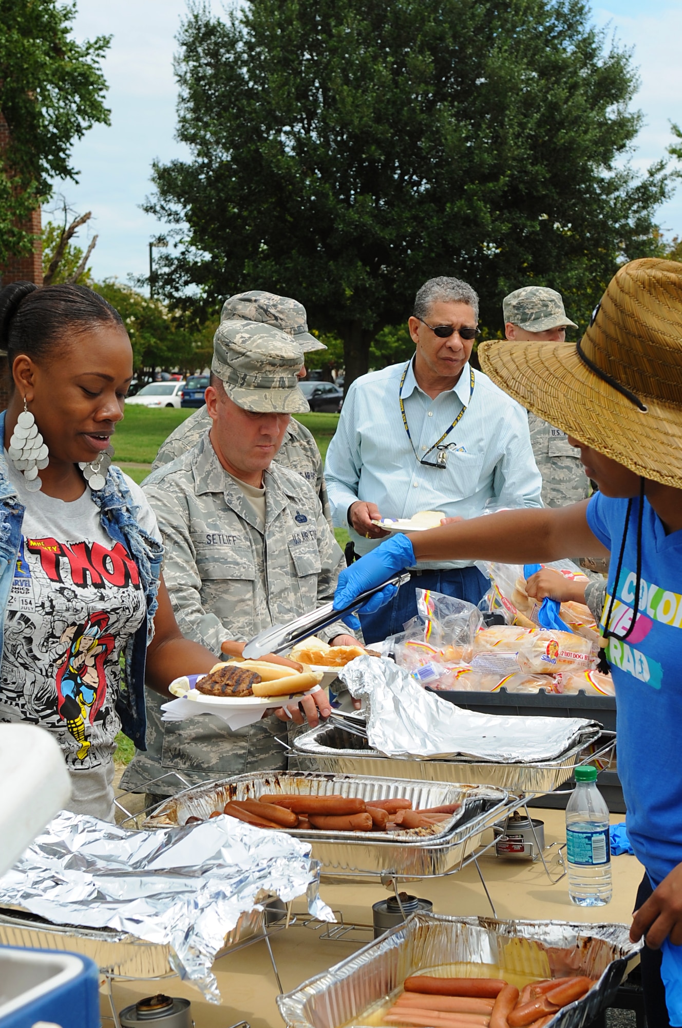 Service members and their families enjoy an outdoor cookout during the “We Are Family” campaign reunion at Langley Air Force Base, Va., Aug. 16, 2013. Many volunteers from across the base helped to make the event possible. (U.S. Air Force photo by Airman 1st Class Victoria H.Taylor/Released)