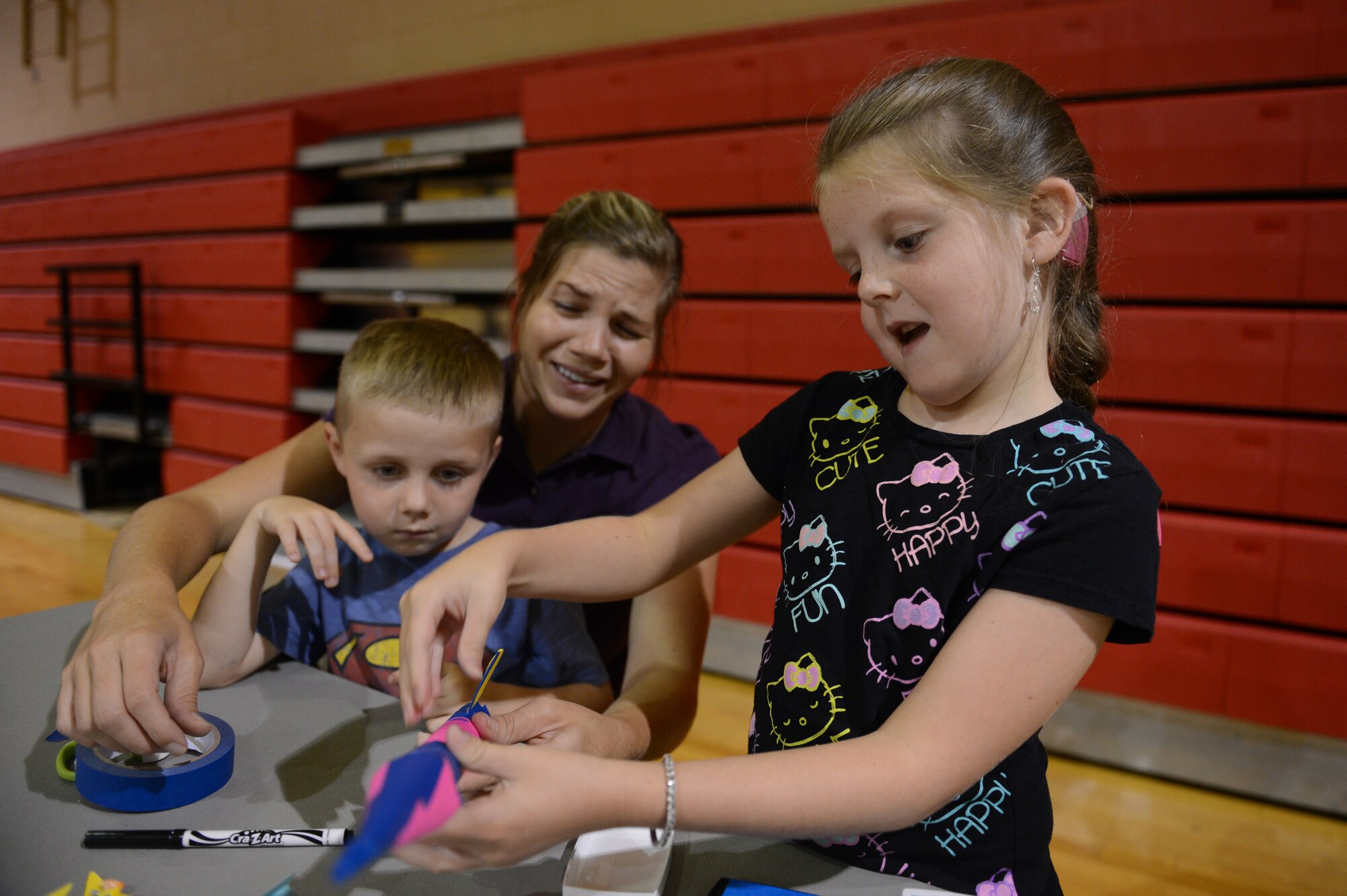 Kensly Grigg, daughter of Charity Grigg, a military spouse, makes a rocket out of construction paper with her mother and brother during the Child Find Clinic and Community Resource Awareness Fair at Shaw Air Force Base, S.C., Aug. 14, 2013. The purpose of the fair was to screen children for health deficiencies and connect families to resources and services provided by military and civilian groups. (U.S. Air Force photo by Airman 1st Class Krystal M. Jeffers/Released)