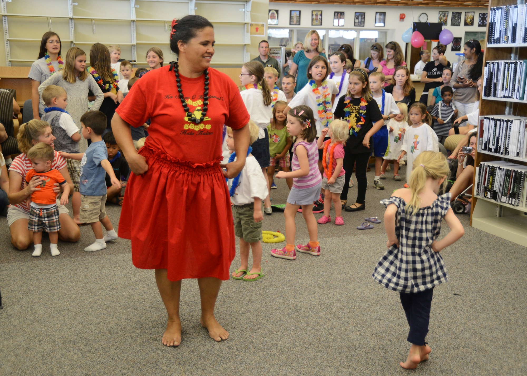 Bonnie McGee, kumu (teacher) of the Ka Ohana O Keolanani Halau group demonstrates basic hula dance moves during the final day of the Summer Reading Program at the Base Library Aug.16.  The students collectively read 12,550 books this summer. Last year the total count was around 9,100. (U.S. Air Force photo by Rebecca Amber) 