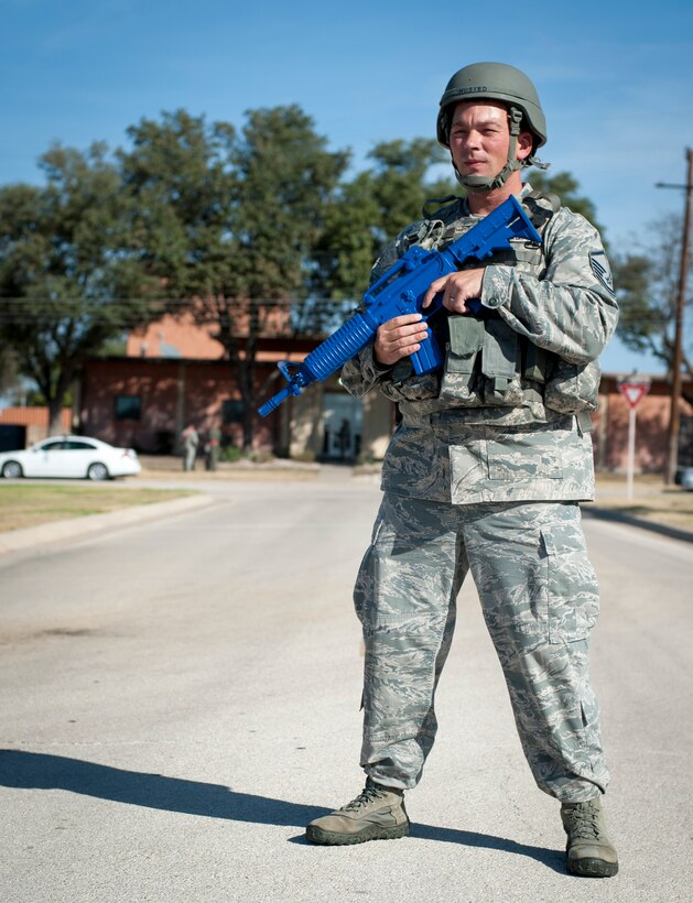 Master Sgt. Joey Husted, 47th Security Forces Squadron traffic control point controller, guards a road during an active shooter scenario at Laughlin Air Force Base, Texas, Aug. 14, 2013. A cordon is established during an emergency scenario to ensure the safety of other base residents in the area. (U.S. Air Force photo/Senior Airman John D. Partlow)