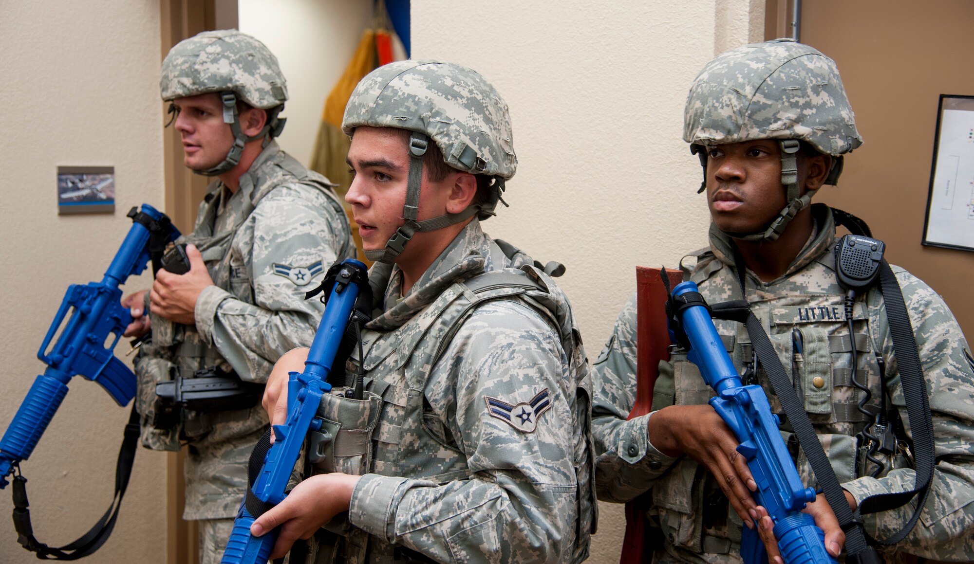From left to right, Airmen 1st Class Mark Walker Jr., Corey Kennedy and James Little III, all 47th Security Forces Squadron patrolmen, stand ready after clearing a building of threats during an active shooter exercise at Laughlin Air Force Base, Texas, Aug. 14, 2013. The three patrolmen swept the building to ensure all simulated victims and suspects were properly handled. (U.S. Air Force photo/Senior Airman John D. Partlow)