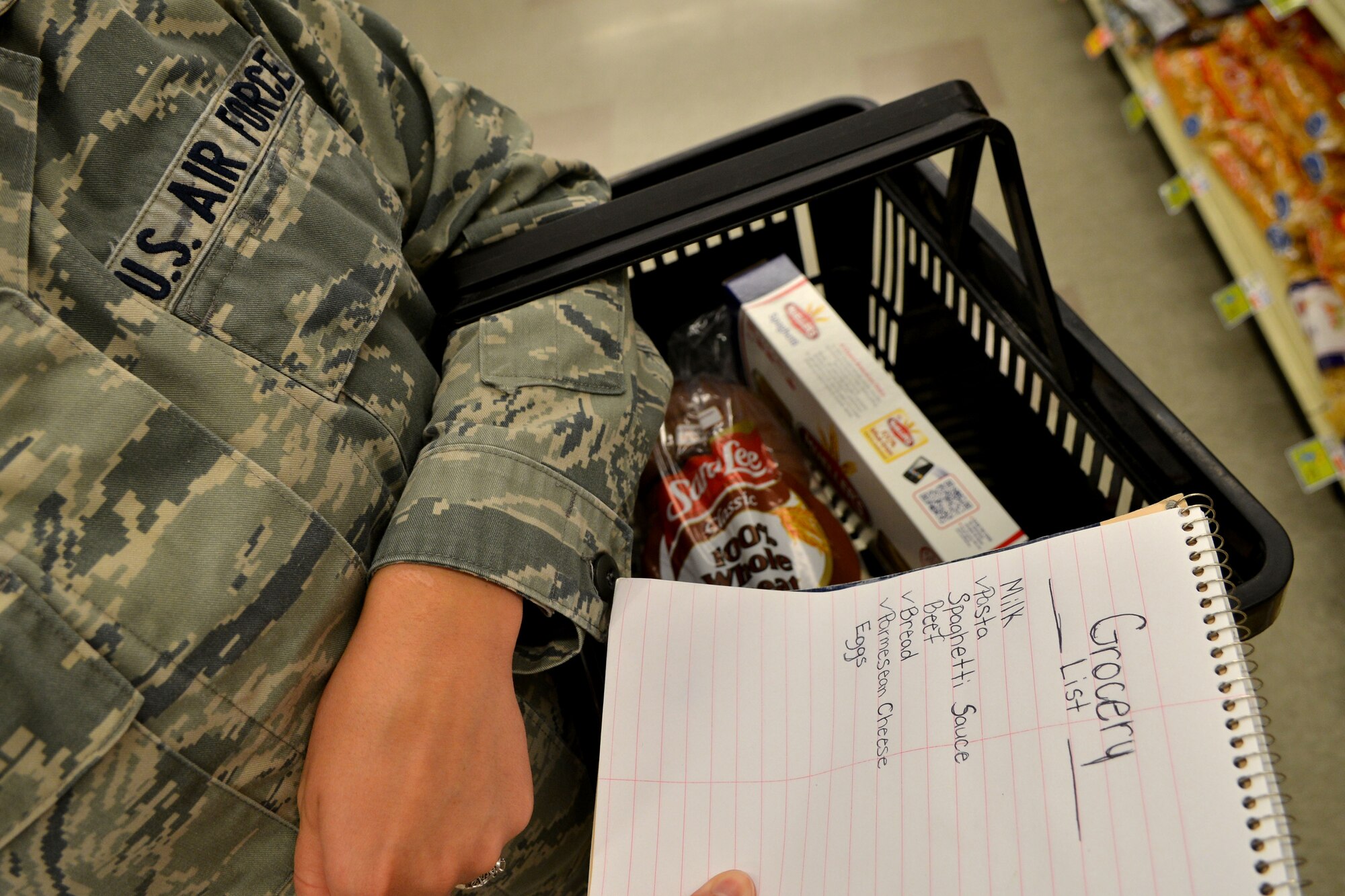 An Airman goes grocery shopping while trying to make healthier decisions at Shaw Air Force Base, S.C., Aug. 18, 2013. The Health and Wellness Center at Shaw recently offered a program called “Grocery Cart Guidance,” in which a registered dietician visited the commissary to help shoppers make better grocery decisions. (U.S. Air Force photo by Airman 1st Class Ashley L. Gardner/Released)