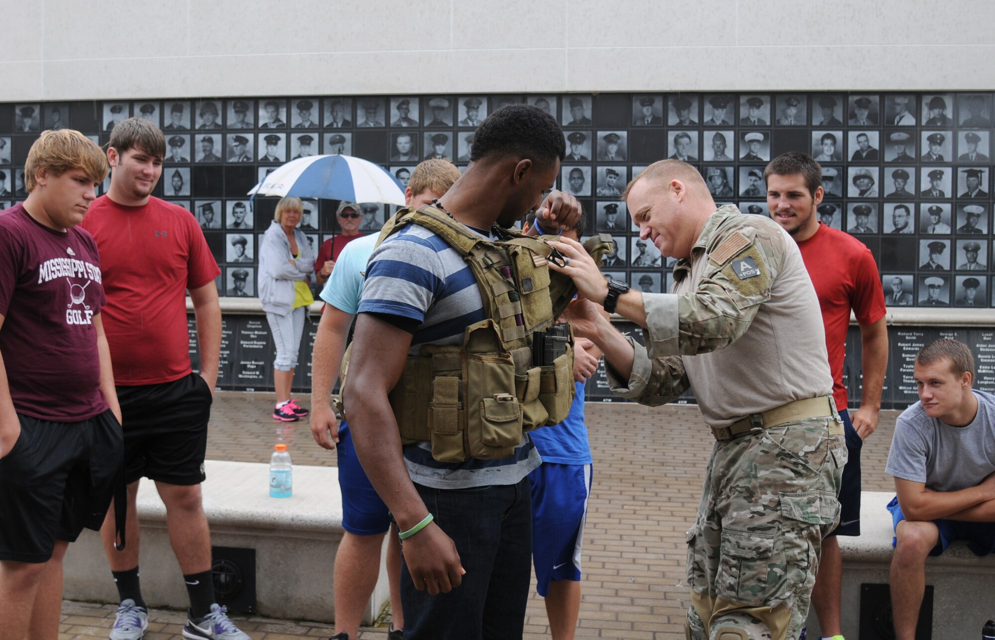 Senior Master Sgt. Bradley Reilly, 334th Training Squadron combat control operators course superintendent, assists a St. Martin High School student try on body armor during a leadership seminar with the school’s senior football players Aug. 17, 2013, at the Mississippi Vietnam Veterans Memorial in Ocean Springs, Miss. The seminar was a collaboration of the St. Martin Gridiron Club and Keesler personnel, who briefed the seniors on good attitudes, values, beliefs and teamwork.  (Courtesy photo by Kemberly Groue)