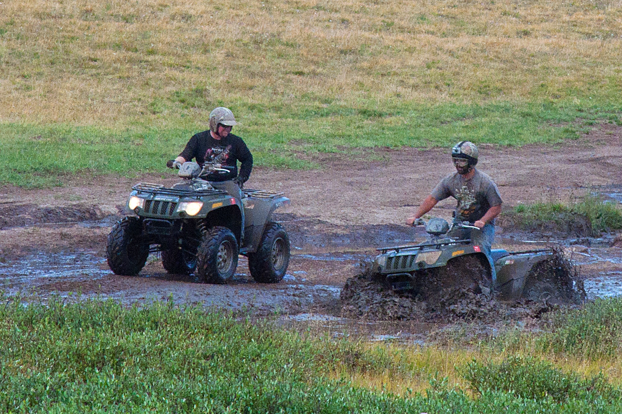 130817-F-GZ967-045 Shane Black and Kyle Holt, Outdoor Recreation employees, ride through a deep mud puddle as they try to keep up with the rest of the group’s riders. The pair was with the F.E. Warren Air Force Base, Wyo., Outdoor Recreation as the chaperones for an ATV adventure at Albany Lodge, Albany, Wyo.  (U.S. Air Force photo by Airman 1st Class Brandon Valle)