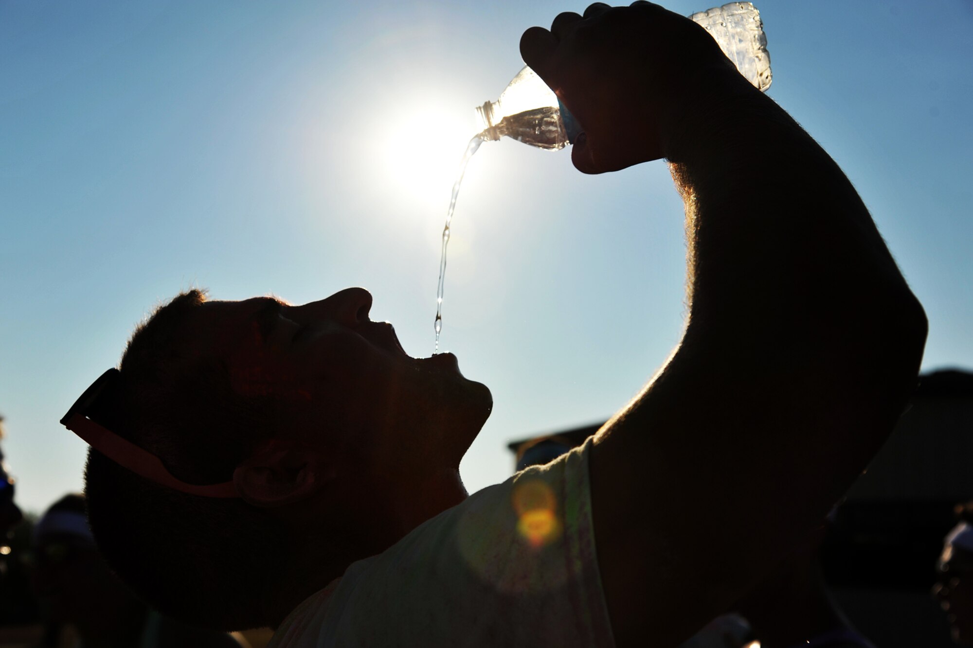 GOODFELLOW AIR FORCE BASE, Texas-- Airman 1st Class Robert Bruccoleri, 312th Training Squadron student, drinks from a bottle of water after running the Sexual Assault Prevention and Response Color Race on Kiowa Trail Aug 17. The SAPR Color Race was held to help bring awareness to preventing and responding to sexual assaults. (U.S. Air Force photo/ Senior Airman Michael Smith) 