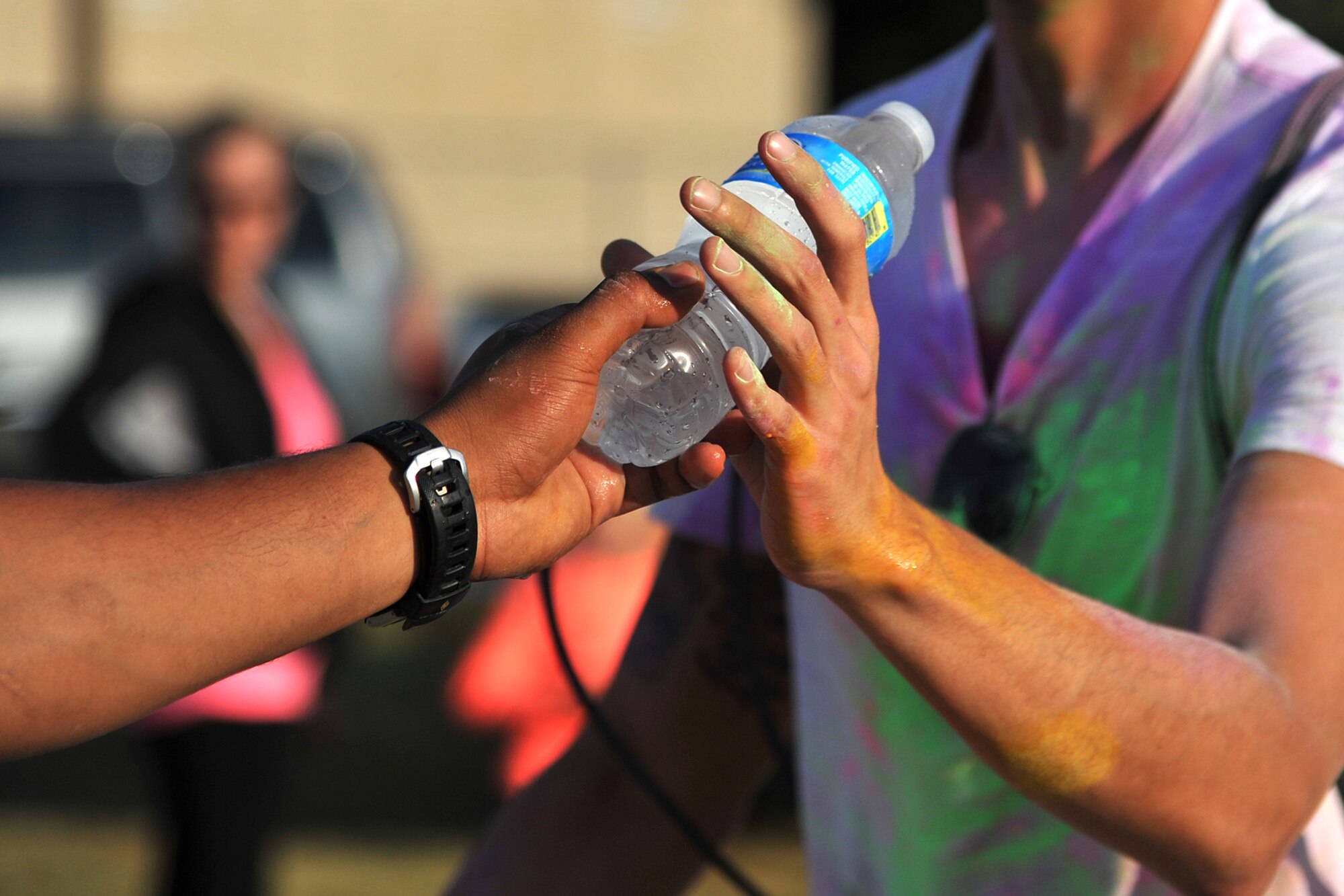 GOODFELLOW AIR FORCE BASE, Texas-- A volunteer hands water to a runner after the Sexual Assault Prevention and Response Color Race on Kiowa Trail Aug 17. More than 100 participants came to show support SAPR by running the 5k. (U.S. Air Force photo/ Senior Airman Michael Smith) 