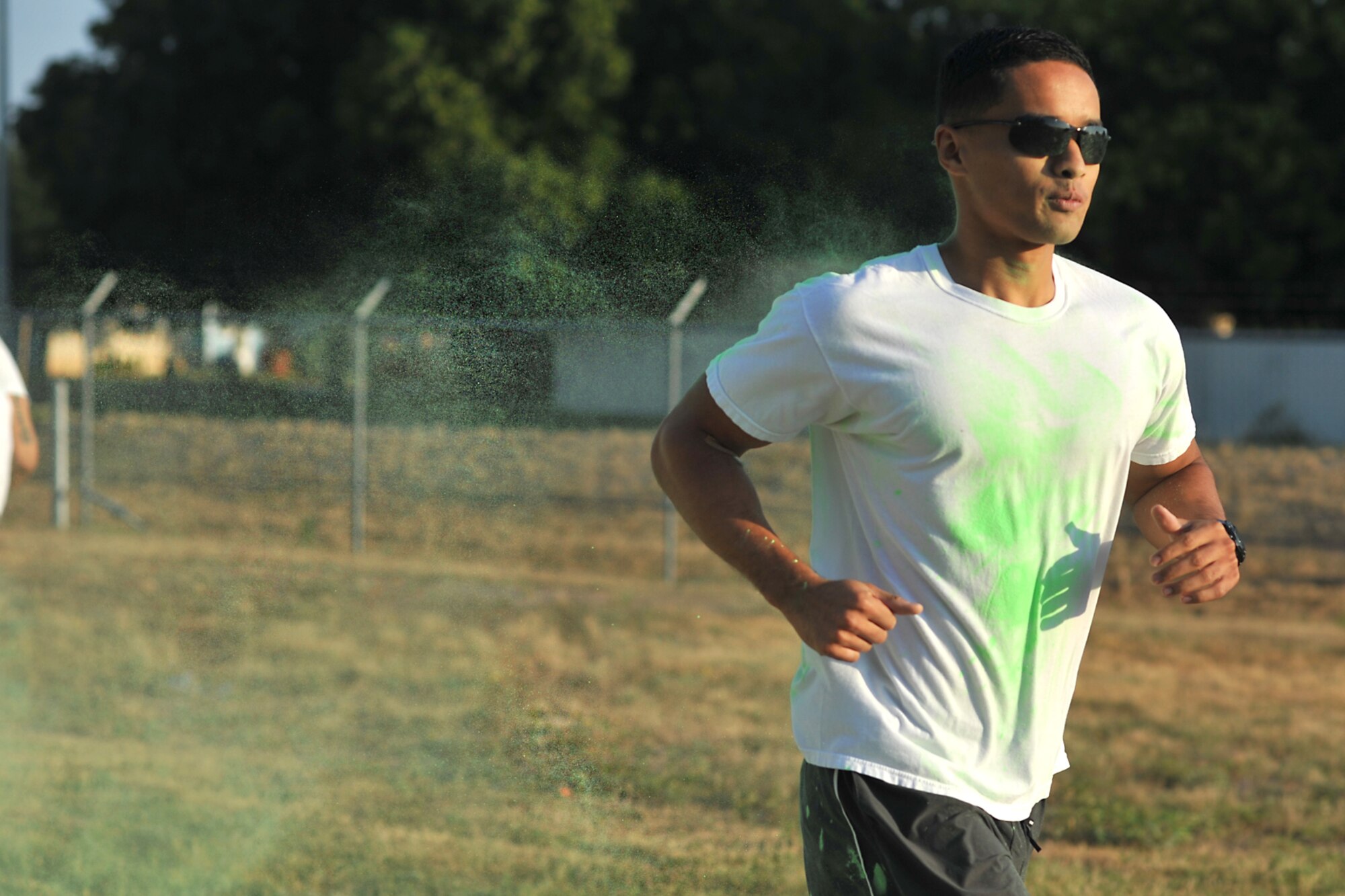 GOODFELLOW AIR FORCE BASE, Texas-- 1st Lt. Frederick Freeman, 17th Comptroller Squadron deputy budget officer, runs through a cloud of green powder during the Sexual Assault Prevention and Response Color Race on Kiowa Trail Aug 17. Each participant of the race ran through several color stations where colored powder would be thrown. (U.S. Air Force photo/ Senior Airman Michael Smith) 