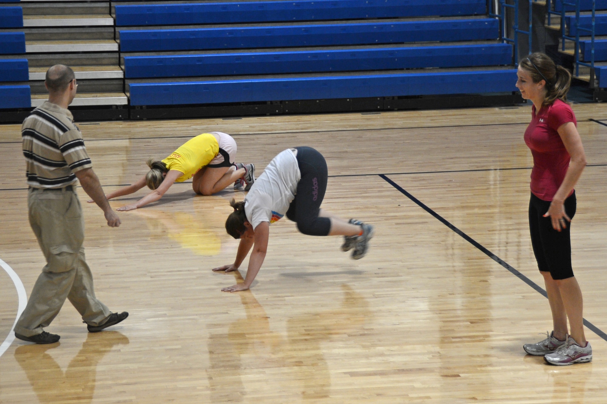 Geoffrey Miller (left), 48th Aerospace Medicine Squadron exercise physiologist, coaches three participants during the High Intensity Interval Training class Aug. 9, 2013. H.I.I.T. is a free 30-minute program designed to improve muscular endurance in a fast-paced, total-body workout. (U.S. Air Force photo by Trevor T. McBride/Released)      