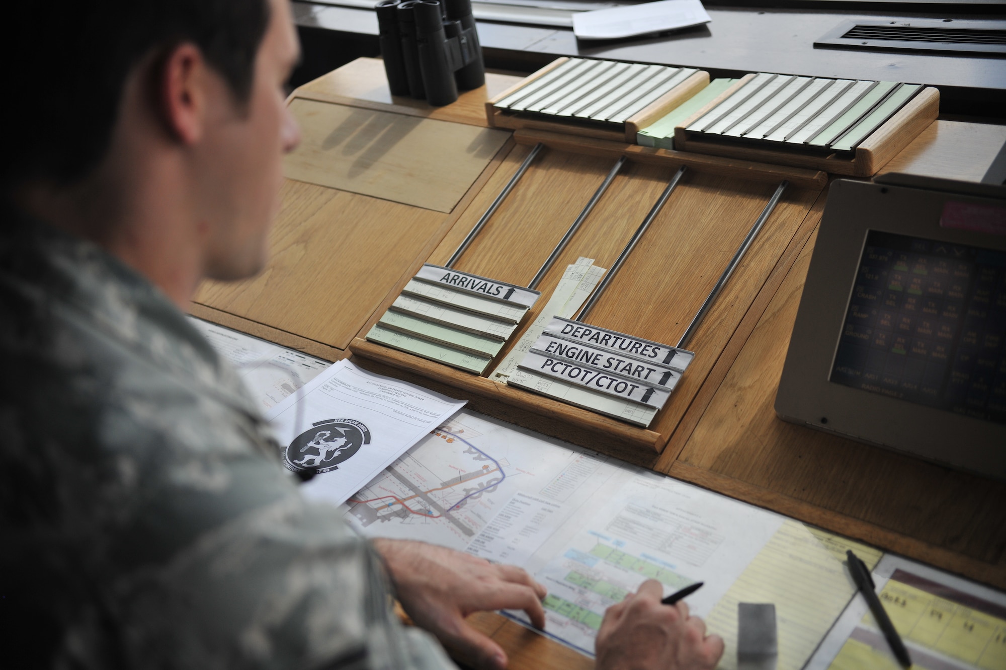U.S. Air Force Staff Sgt. Justin Kobler, 321st Special Tactics Squadron combat controller, reviews the departures and arrivals of aircraft Aug. 7, 2013, on RAF Mildenhall, England. Tower controllers let pilots know when to start their engines, taxi and take off. Tower controllers also make sure aircraft each have a time slot to land and take off, ensuring runway safety. (U.S. Air Force photo by Airman 1st Class Kyla Gifford/Released)