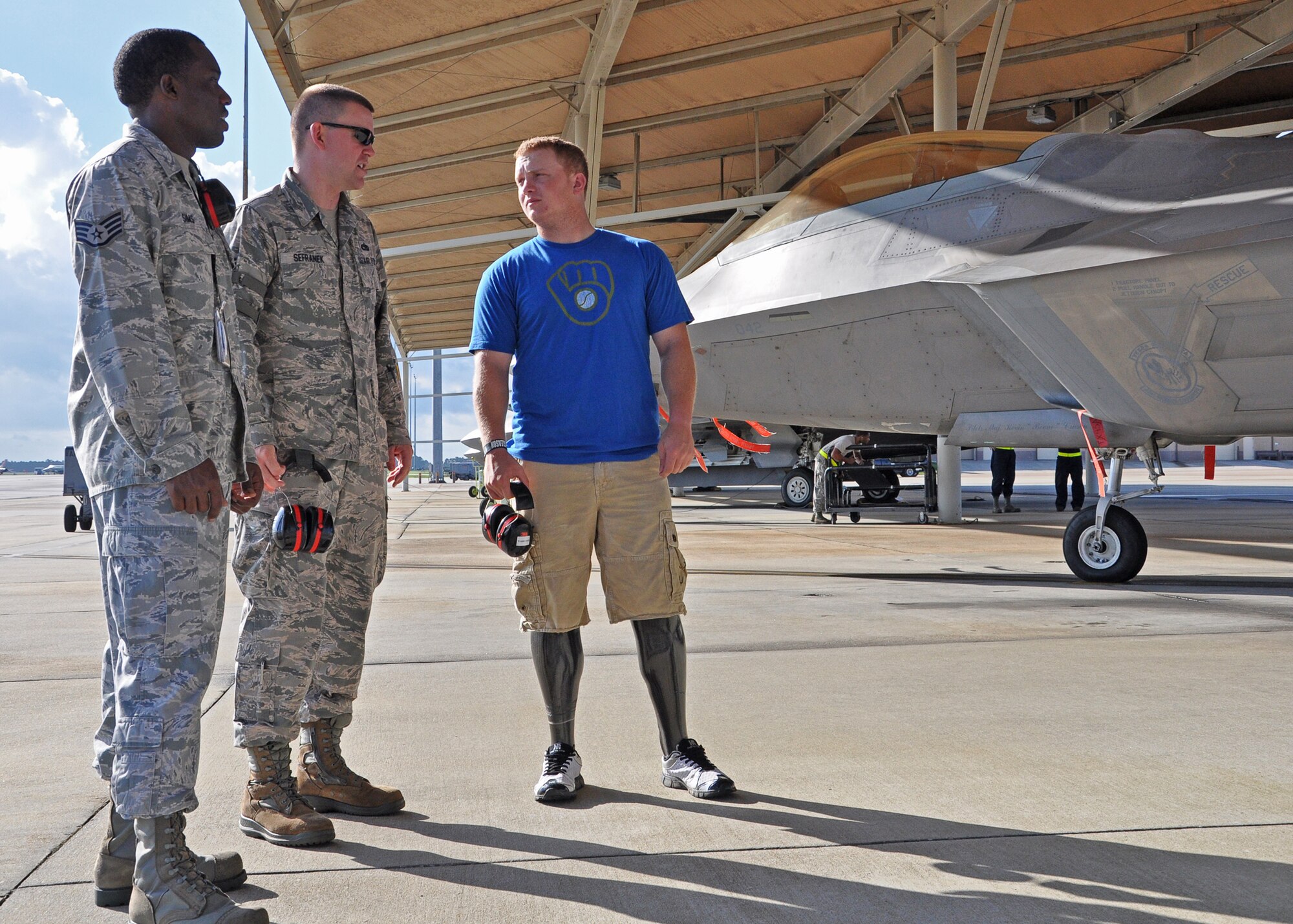 Medically Retired Lance Cpl. Josh Wege talks with Tech. Sgt. John Sefranek, 43rd Aircraft Maintenance Unit, and William Sims, 325th Aircraft Maintenance Squadron, about the capabilities of the F-22 Raptor Aug. 14 on Tyndall’s flight line. He visited Tyndall and toured an F-22 after traveling to Panama City with the Wounded Warrior Amputee Softball Team. Mr. Wege travels around the country with the WWAST, which spreads awareness of the sacrifices and resilience of our military, and highlights their ability to rise above any challenge.