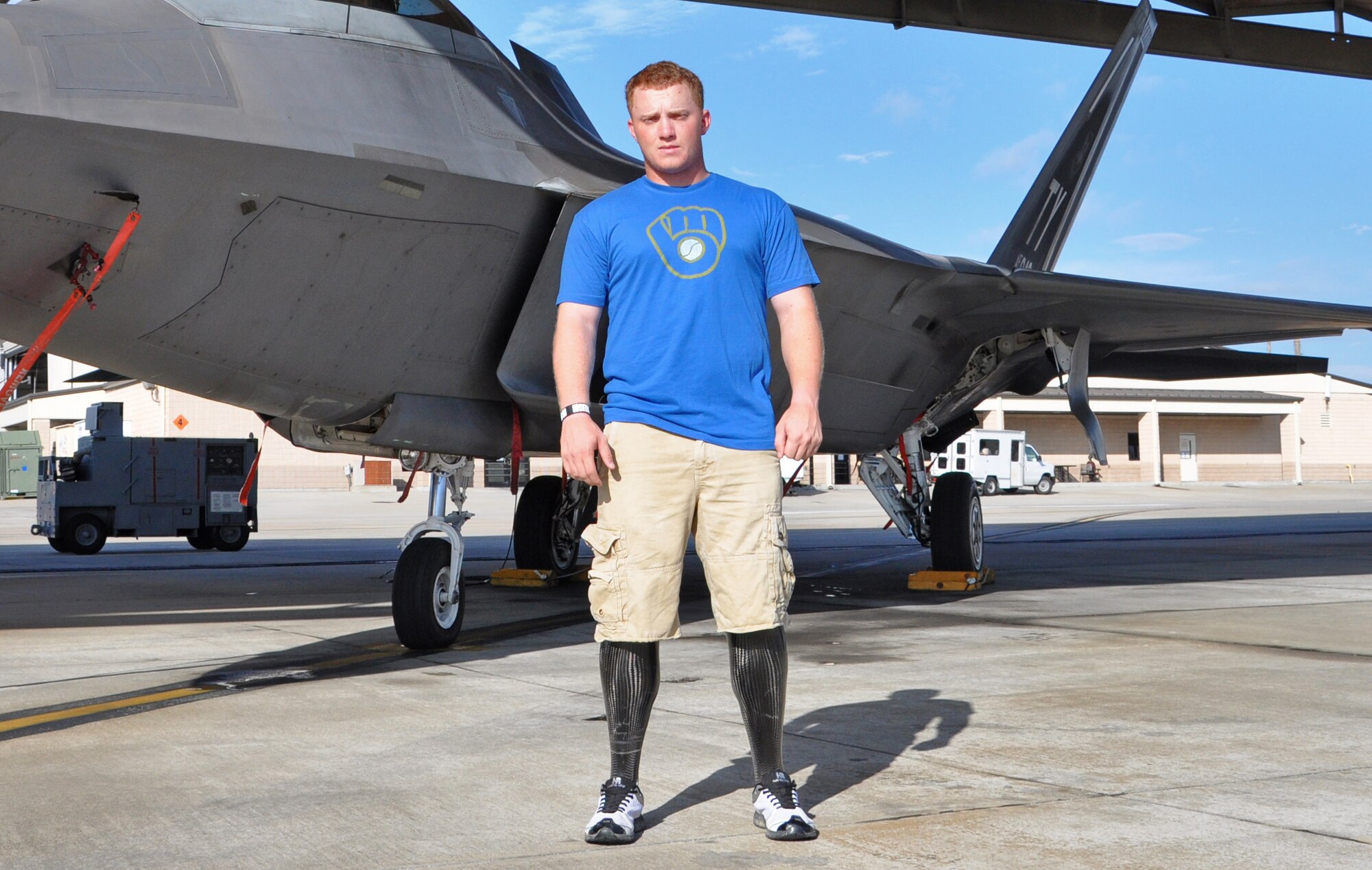 Medically Retired Lance Cpl. Josh Wege poses in front of an F-22 Raptor Aug. 14 on Tyndall’s flight line. He visited Tyndall and toured an F-22 after traveling to Panama City with the Wounded Warrior Amputee Softball Team. Mr. Wege travels around the country with the WWAST, which spreads awareness of the sacrifices and resilience of our military, and highlights their ability to rise above any challenge. 