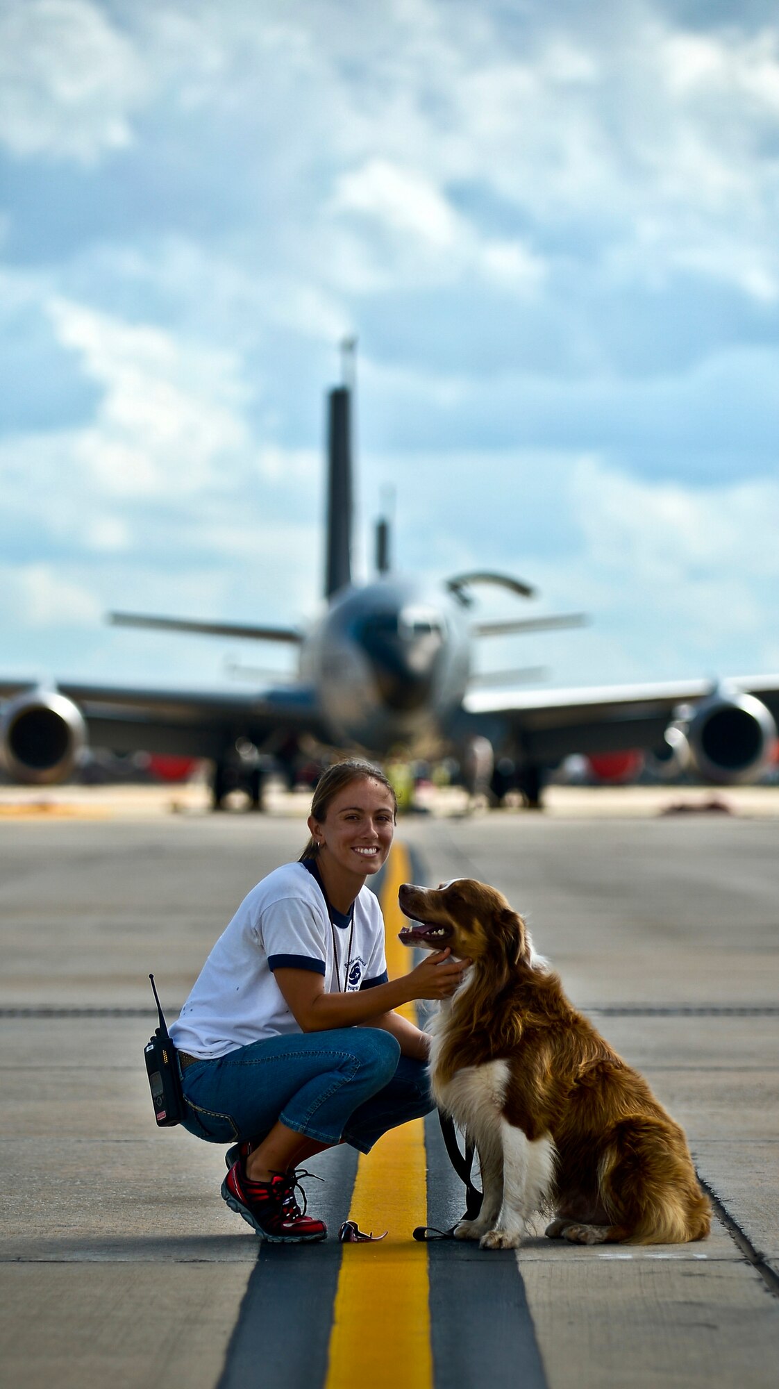 Lindsey Garven, ecologist and 6th Air Mobility Wing Bird/Wildlife Aircraft Strike Hazard manager, and her assistant Tango, a wildlife chasing border collie, rest in front of one of the many KC-135 Stratotankers they protect, MacDill Air Force Base, Fla., Aug. 5, 2013. Garven and Tango are entrusted with ensuring the area on and around MacDill’s runways are free and clear of wildlife.