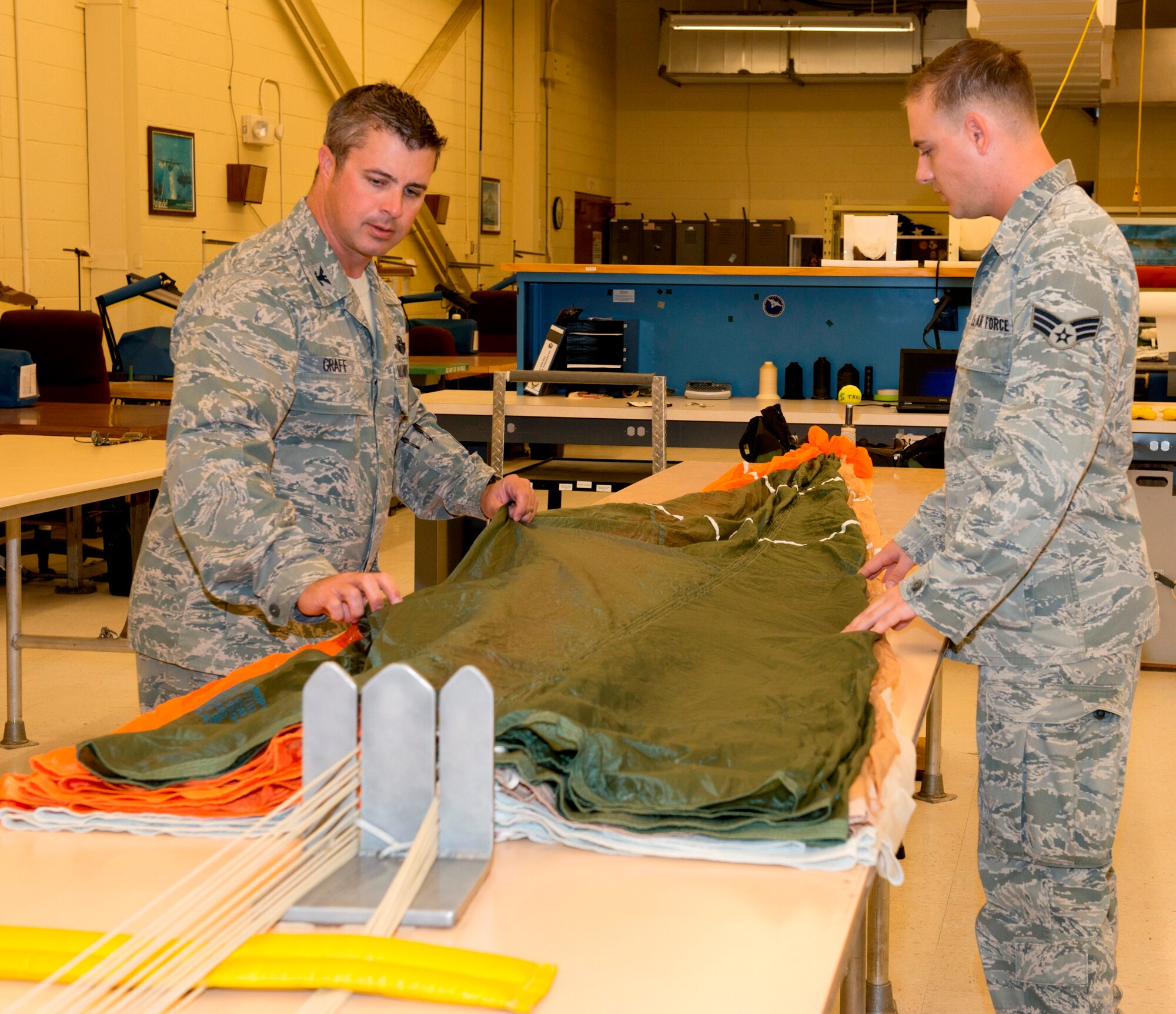 Colonel David E. Graff, 325th Fighter Wing commander, helps Senior Airman Brandon Keiper, 325th Operations Support Squadron aircrew flight equipment technician, fold and pack a parachute Aug. 16 as part of the Airman’s Shadow program. The program provides an opportunity for the commander to get a first-hand look at what Tyndall Airmen are doing.  (U.S. Air Force photo by Lisa Norman) 