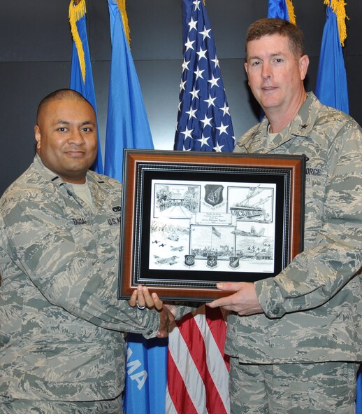 Brig. Gen. Gene Kirkland, commander of the Oklahoma City Air Logistics Complex, presents a “2012 Pacific Air Forces Company Grade Officer of the Year” plaque to 1st Lt Pelenato Tagoai, left, of the 76th Propulsion Maintenance Group. The lieutenant was honored recently for his work while assigned to the 718th Aircraft Maintenance Squadron at Kadena Air Base, Japan. (Air Force photo by Julie LaFollette)