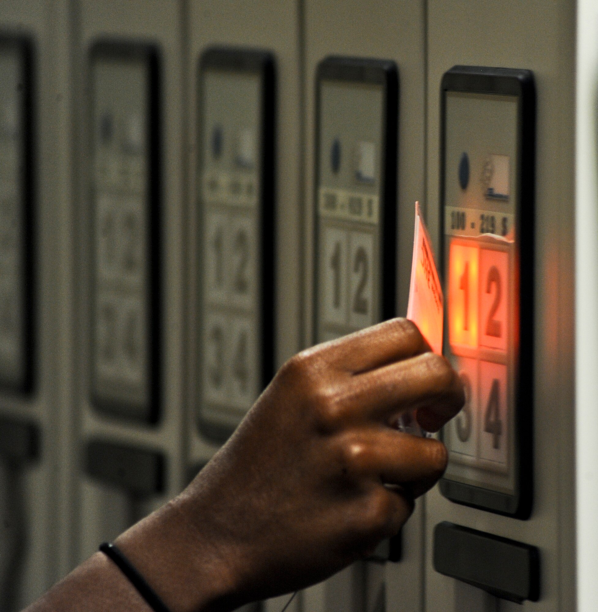 Pharmacy technicians swipe their individually unique micro-chipped badges in order to retrieve the illuminated bin containing a patient's prescriptions at the 6th Medical Group on MacDill Air Force Base, Fla., Aug. 19, 2013. If someone attempts to access the Global Script Locator system without a special access badge an alarm will sound. (U.S. Air Force photo by Senior Airman Michael Ellis/Released)