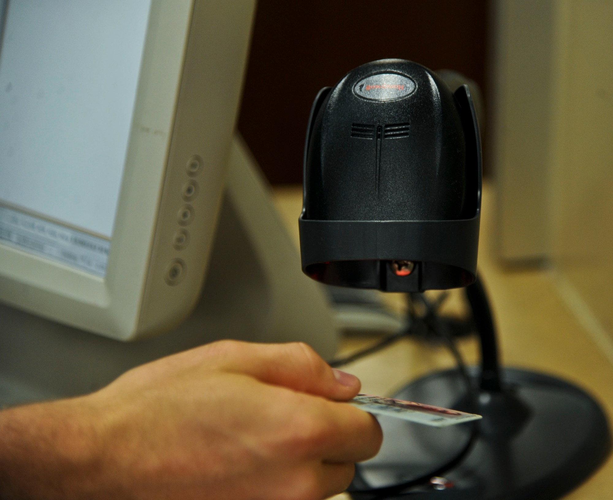 As a staff member scans a patient's identification card, a shelf within the Global Script Locator lights up indicating the location of the script at the 6th Medical Group on MacDill Air Force Base, Fla., Aug. 12, 2013. Staff members have individually unique micro-chipped badges that must be swiped in order to retrieve the illuminated bin containing a patient's prescriptions. (U.S. Air Force photo by Senior Airman Michael Ellis/Released)