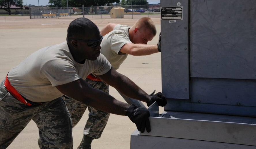 Senior Airmen Keith Jackson, left, and Nicholas Kupferle, 96th Aircraft Maintenance Unit crew chiefs, push an A/M32 diesel generator into position prior to receiving a landing aircraft on Barksdale Air Force Base, La., Aug. 19. The generator provides power to the aircraft prior to take-offs, and after landings, to allow crew chiefs to launch and power down aircraft. (U.S. Air Force photo/Airman 1st Class Andrew Moua)