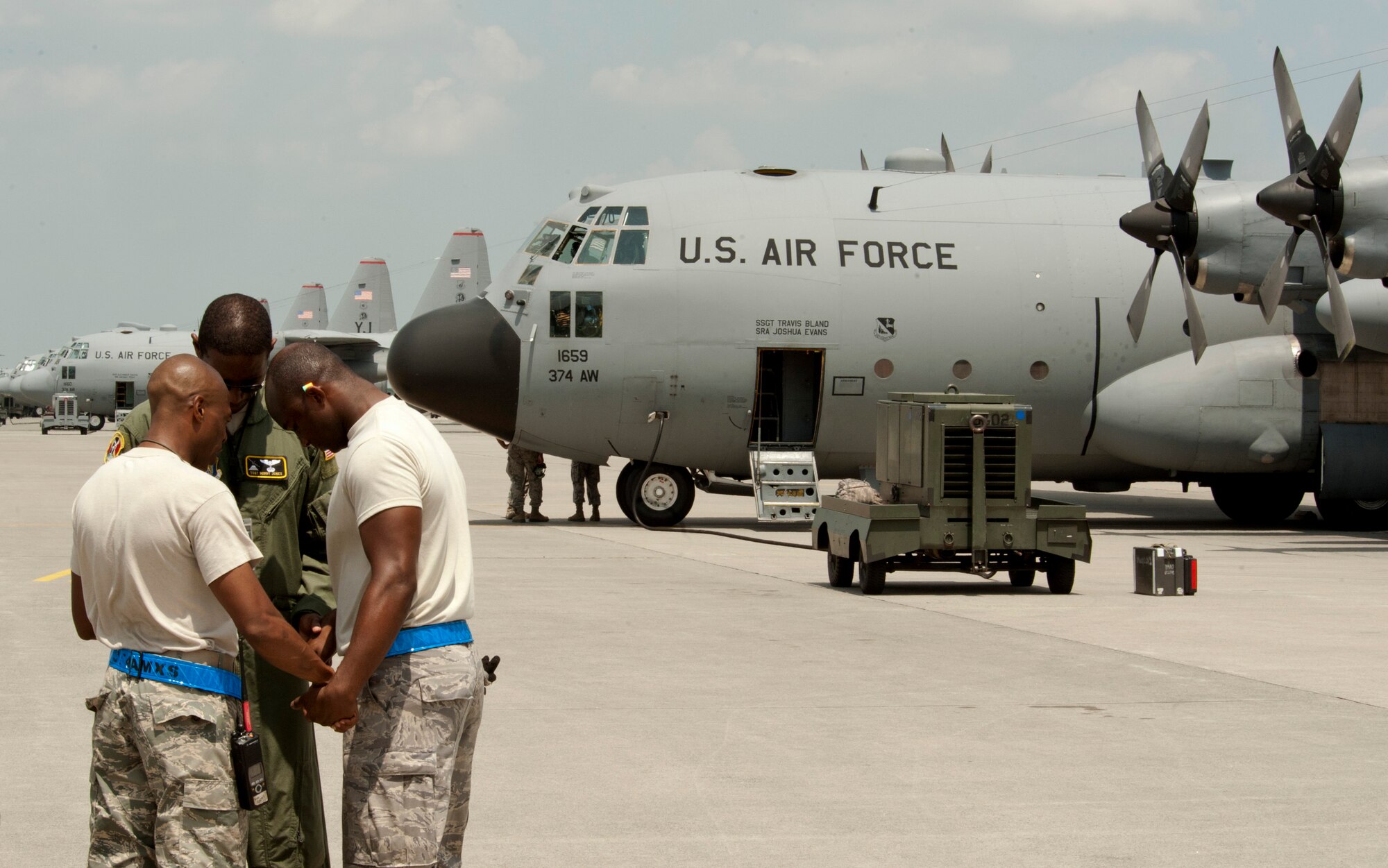 Maintainers come together for a prayer before a large formation mission at Yokota Air Base, Japan, Aug. 19, 2013. Seven C-130s flew in formation practicing airlift tactics and procedures. (U.S. Air Force photo by Senior Airman Michael Washburn)