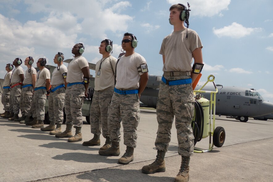 Airmen from the 374th Aircraft Maintenance Squadron look on as a C-130H aircraft prepares for departure before a large formation training operation at Yokota Air Base, Japan, Aug. 19, 2013. (U.S. Air Force photo by 2nd Lt. Jake Bailey) 