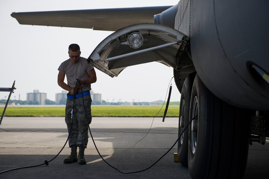 Airman 1st Class Zachary Strobel, 374th Aircraft Maintenance Squadron crew chief, fills air into a C-130 Hercules tire Aug. 17, 2013, at Yokota Air Base, Japan. Strobel was part of a five-man team responsible for getting the aircraft ready for a large formation. (U.S. Air Force photo by Senior Airman Cody H. Ramirez)