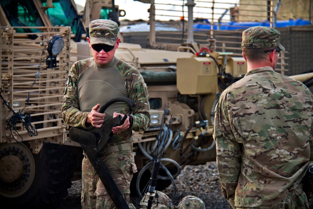 U.S. Army Staff Sgt. Christopher M. Johnson, left, inspects a “Goldie” wire to detect roadside bombs before patrolling to clear routes in Khowst province, Afghanistan, Aug. 14, 2013. Johnson, a combat engineer, is assigned to the 101st Airborne Division's Company A, 4th Brigade Special Troops Battalion, 4th Brigade Combat Team. 