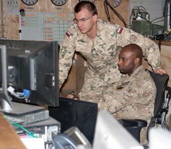 Hard at work in the tactical operations center, Master Sgt. Marccus Cox, U.S. Task Force White Eagle night battle captain, and Capt. Marek Majcher, Polish Task Force White Eagle battle captain, check data.